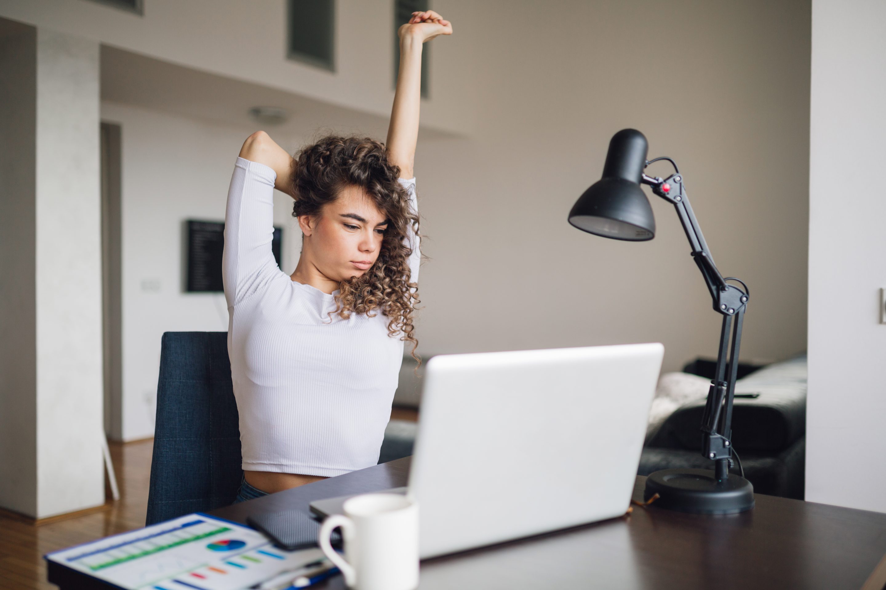 Businesswoman stretching at home desk