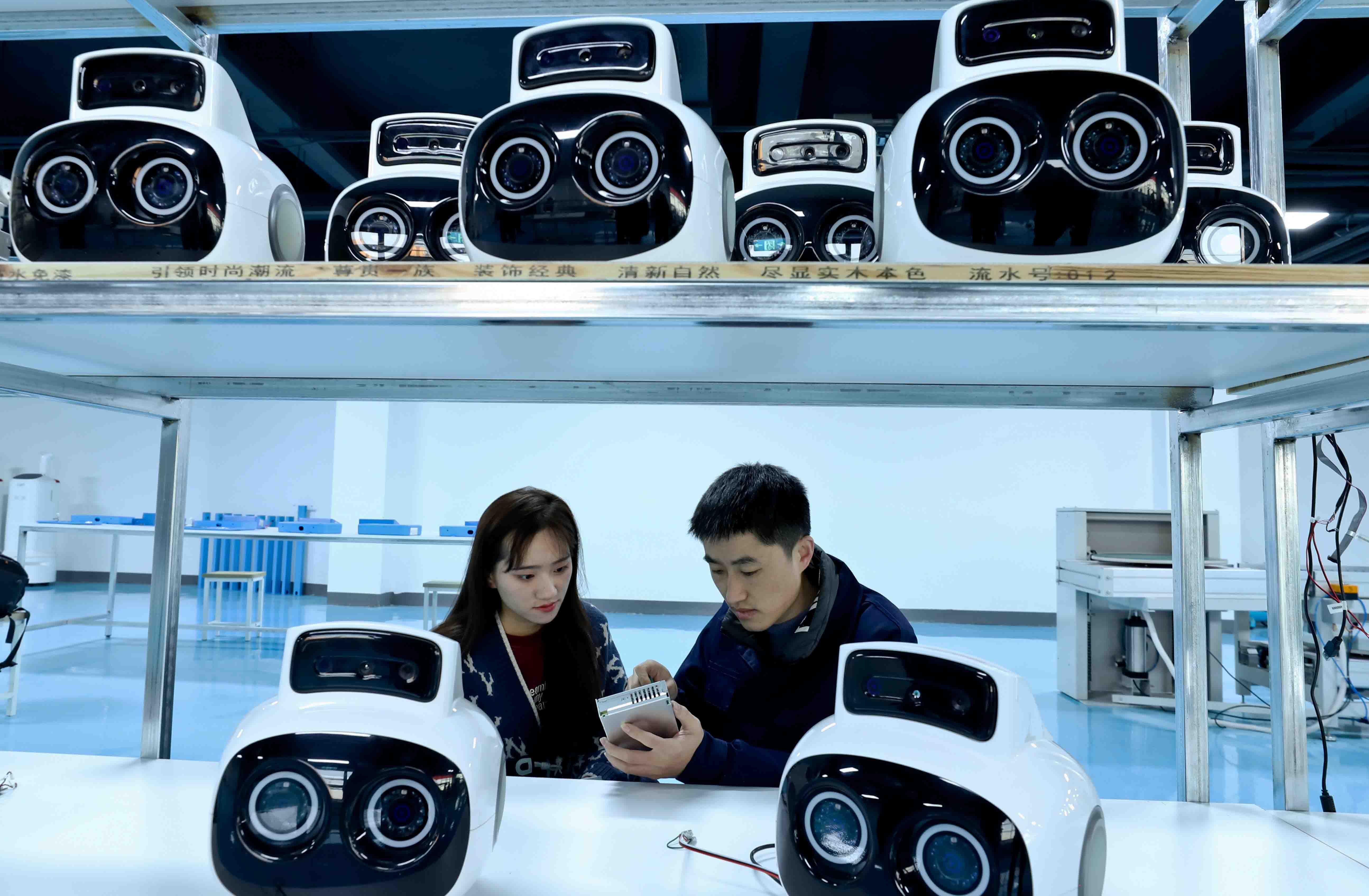 Technicians install a customized robot smart hard disk at an intelligent robot assembly and manufacturing workshop in Zhangye city, Gansu province, China on Mar. 2.