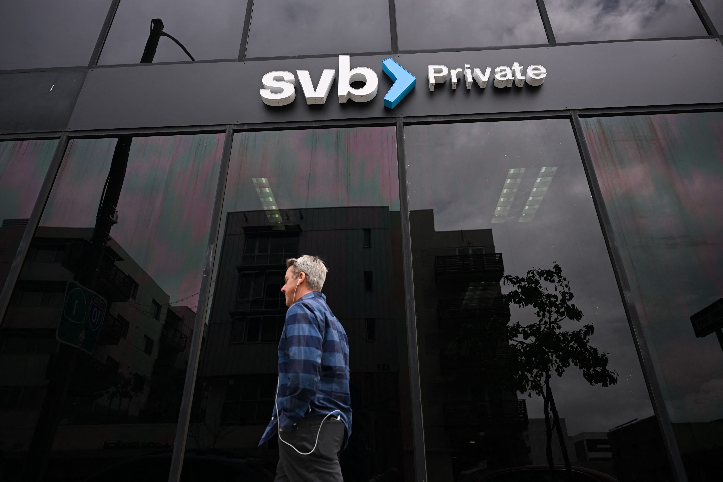 A person walks beneath a Silicon Valley Bank sign