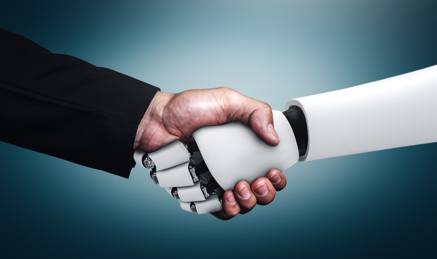 A human hand shaking a robot's hand