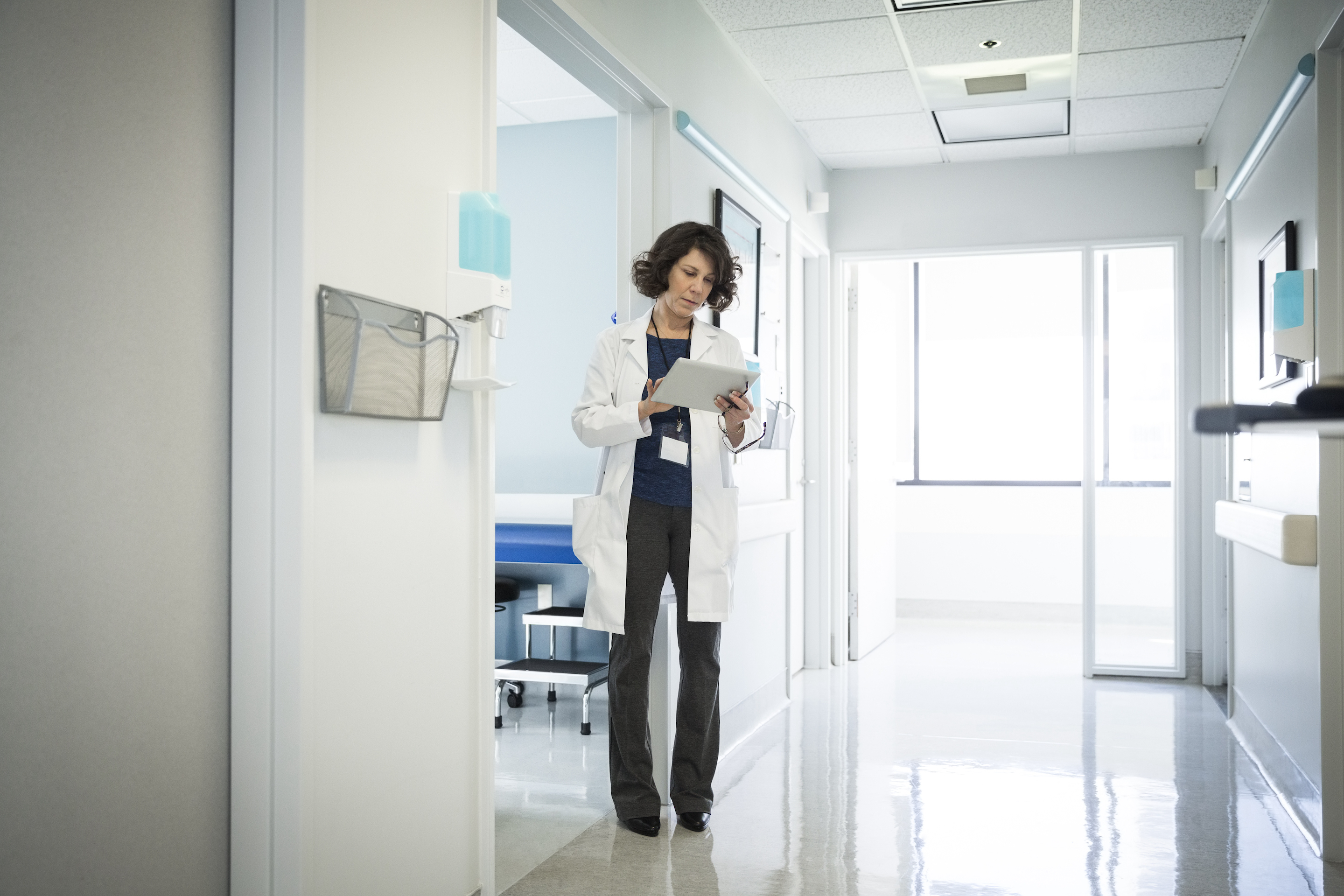 Female doctor using digital tablet in hospital corridor