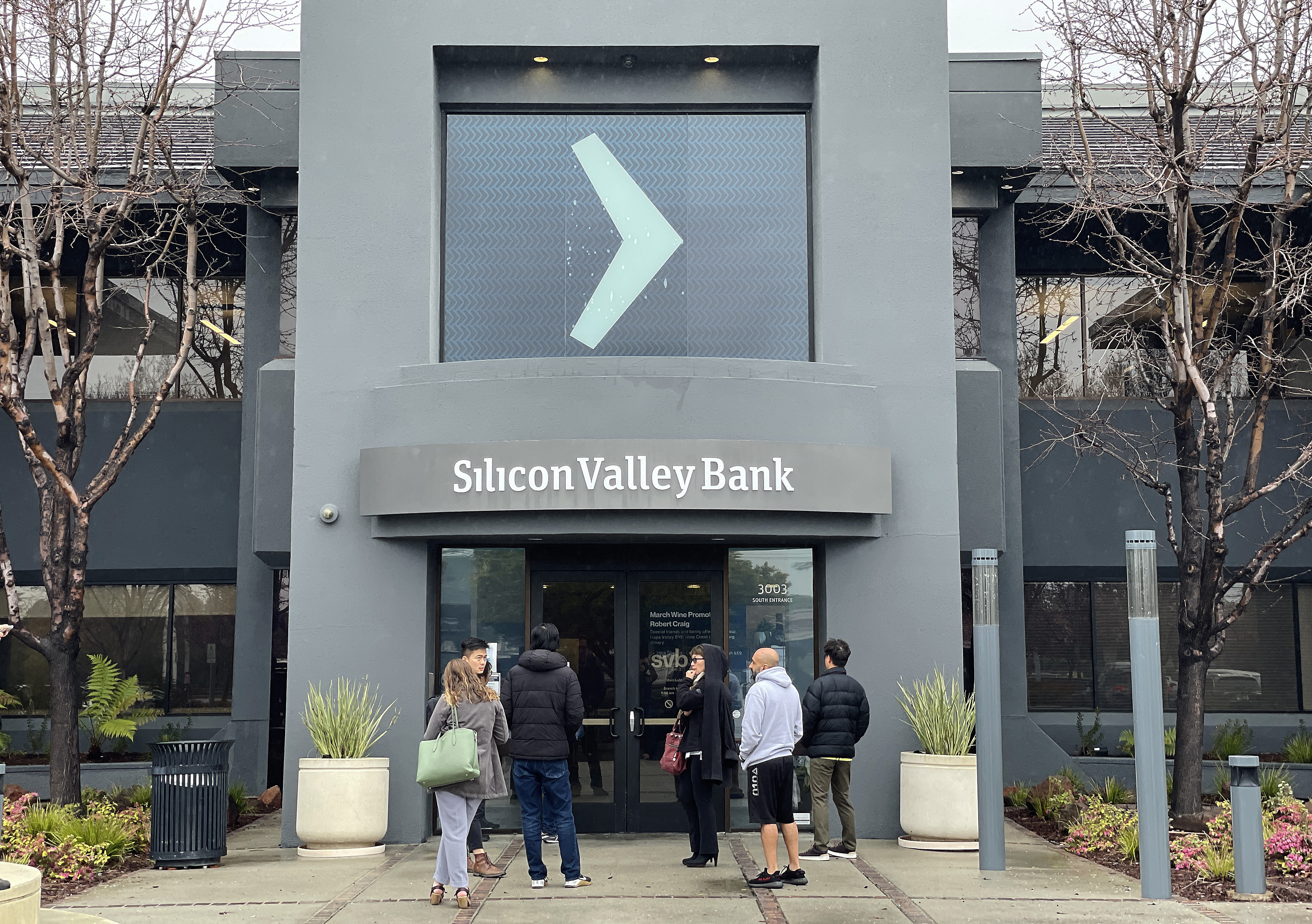 People line up outside the shuttered Silicon Valley Bank headquarters on March 10, 2023, in Santa Clara, Calif.
