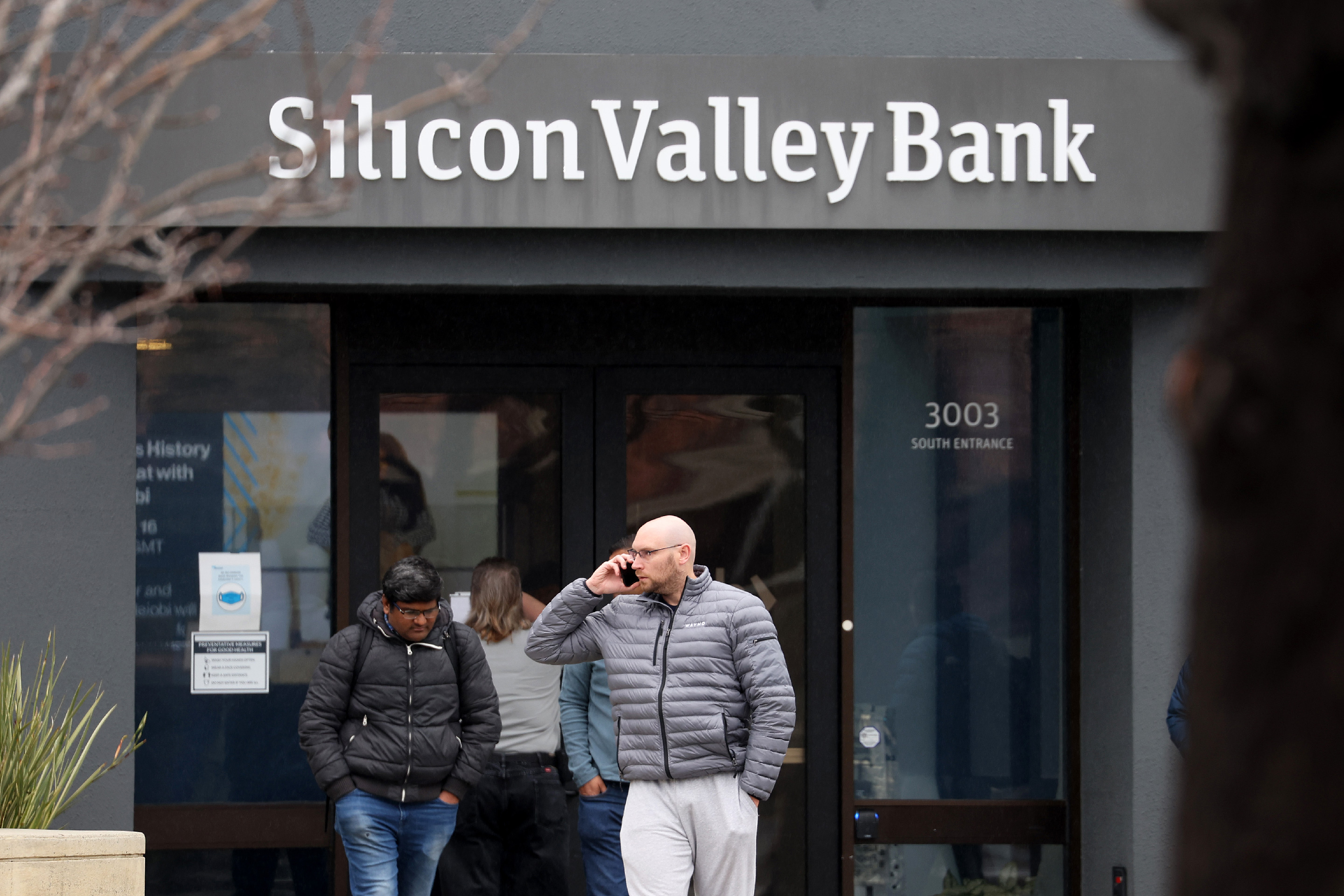 Employees stand outside of the shuttered Silicon Valley Bank (SVB) headquarters on March 10, 2023.