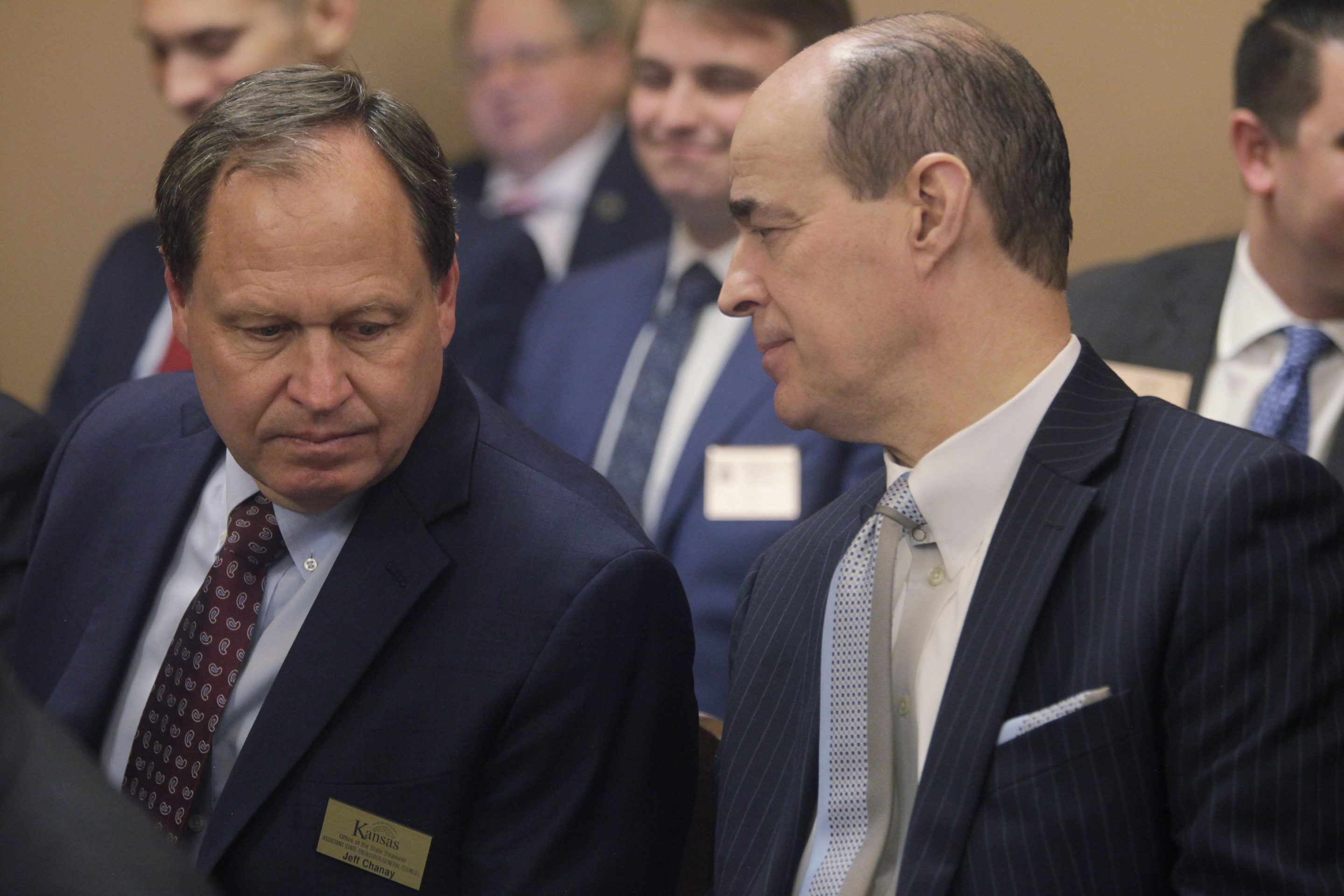 Kansas State Treasurer Steven Johnson, right, confers with Assistant State Treasurer Jeff Chanay during a Kansas Senate committee hearing on legislation aimed at preventing state funds from being invested using environmental, social or governance principles, Tuesday, March 7, 2023, at the Statehouse in Topeka, Kan.