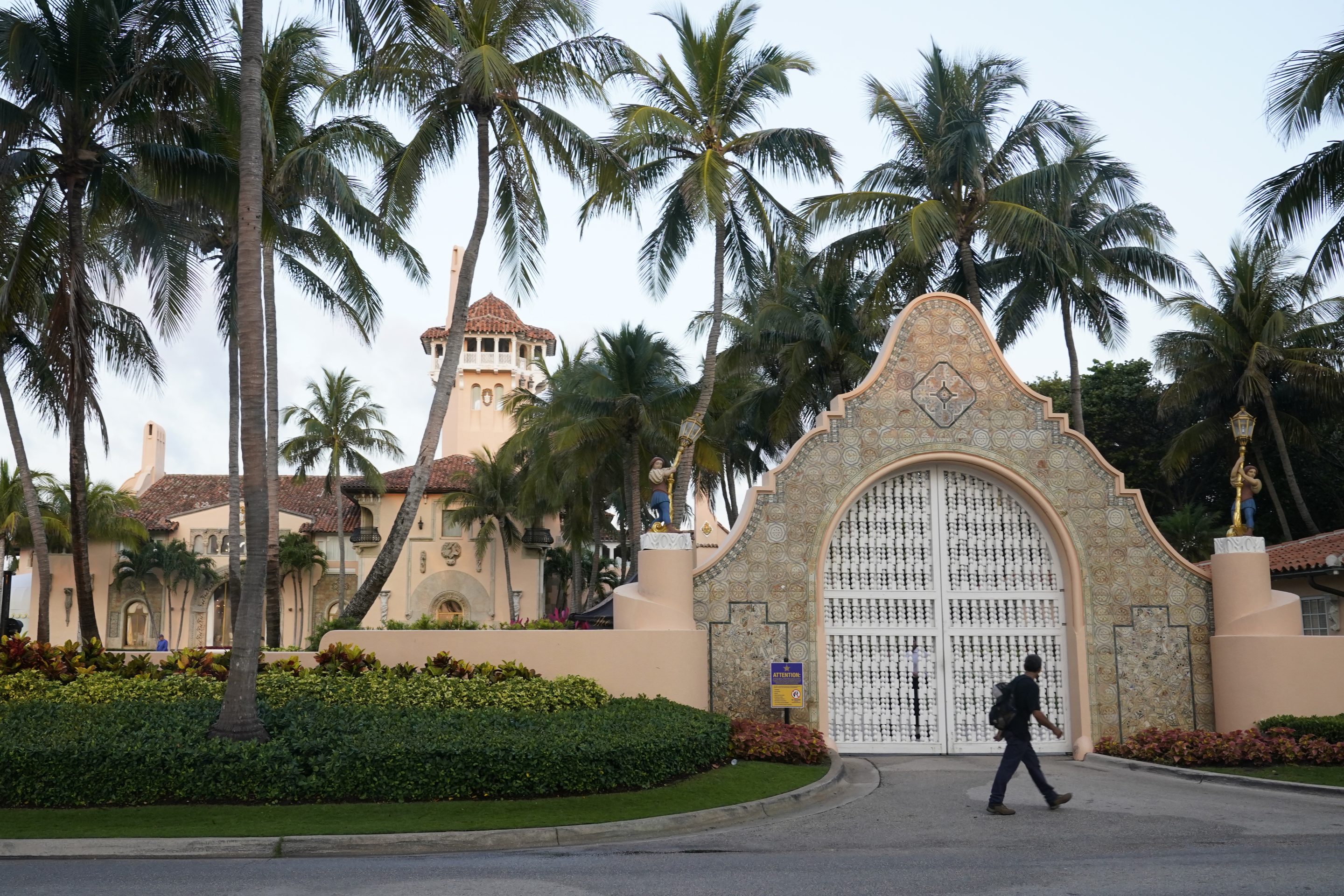 A pedestrian walks by the entrance of the Mar-a-Lago club, Monday, April 3, 2023, in Palm Beach, Fla. 