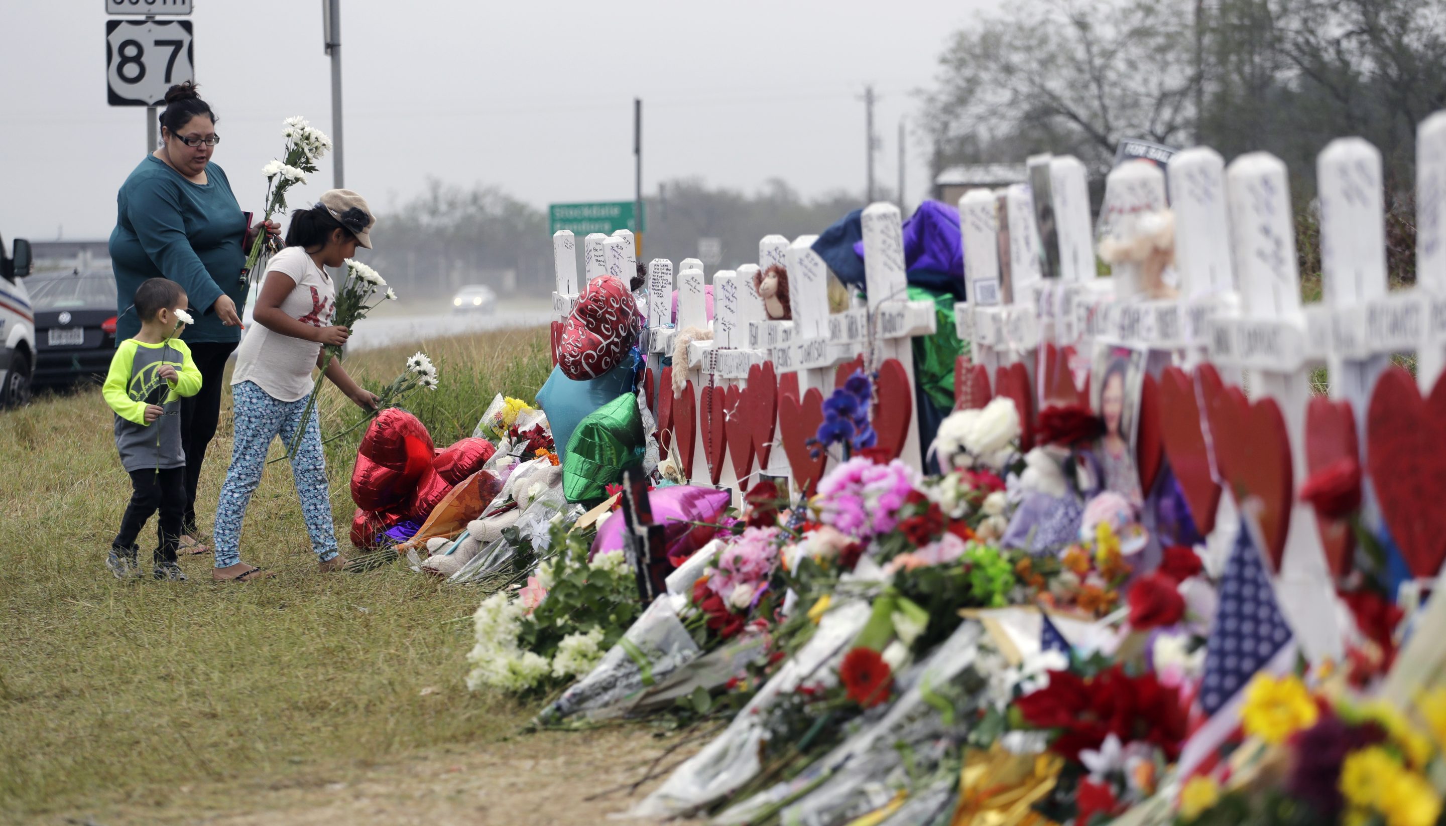 Christina Osborn and her children Alexander Osborn and Bella Araiza visit a makeshift memorial for the victims of the shooting at Sutherland Springs Baptist Church, Nov. 12, 2017, in Sutherland Springs, Texas.