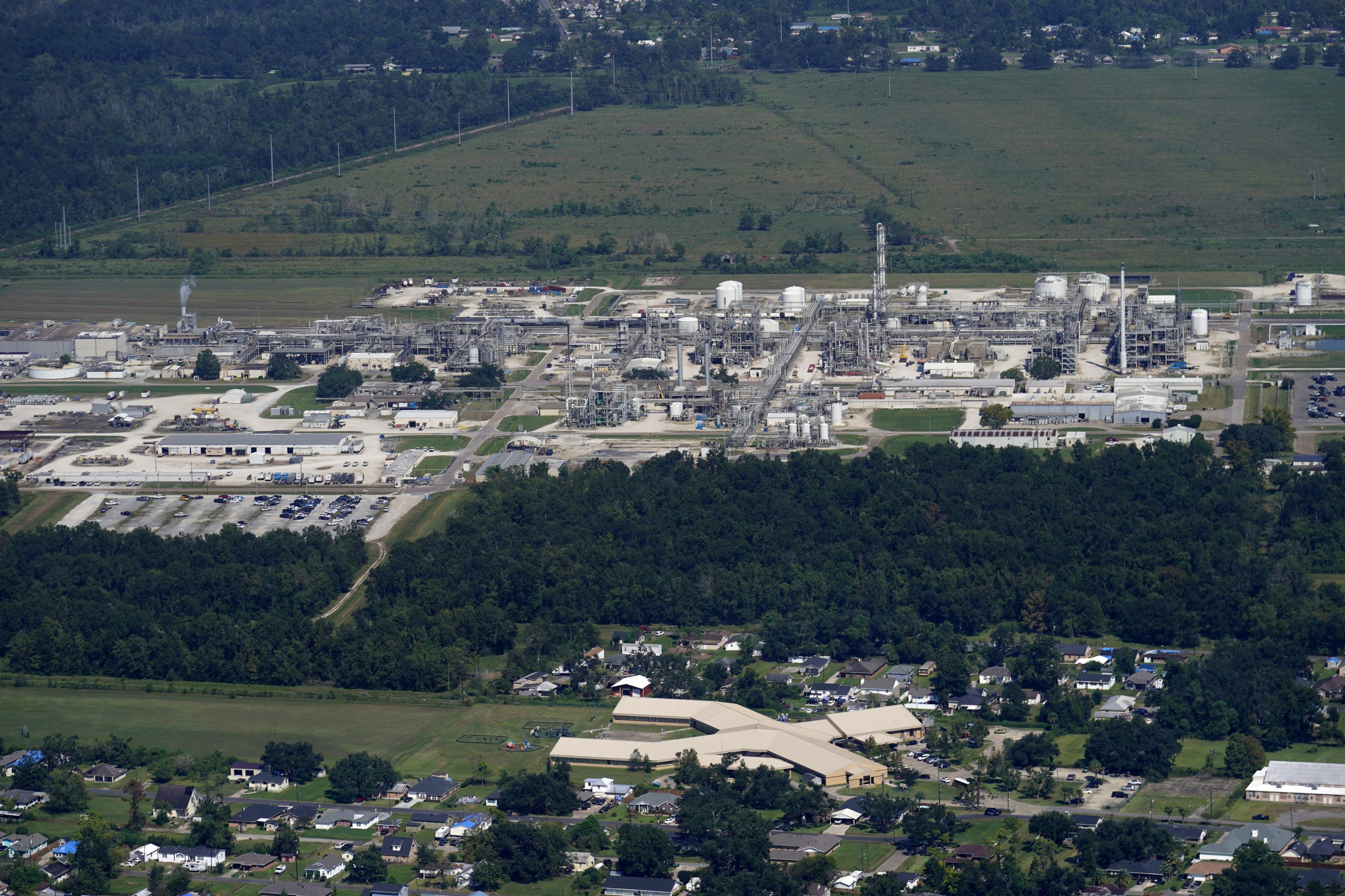 The Fifth Ward Elementary School and residential neighborhoods sit near the Denka Performance Elastomer Plant, back, in Reserve, La., Sept. 23, 2022.