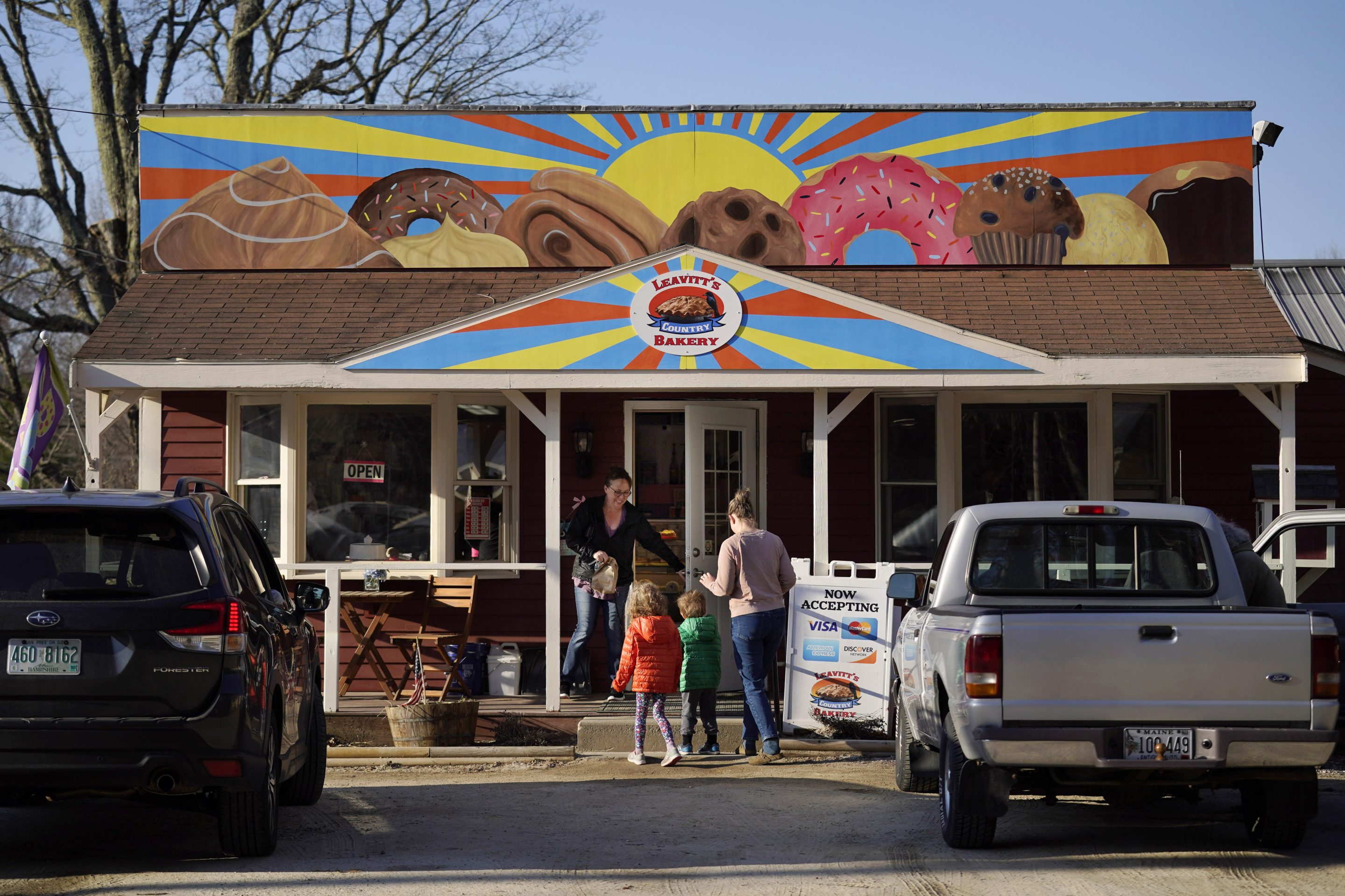 A customer holds the door for a family arriving at Leavitt's Country Bakery, Thursday, April 13, 2023, in Conway, N.H.