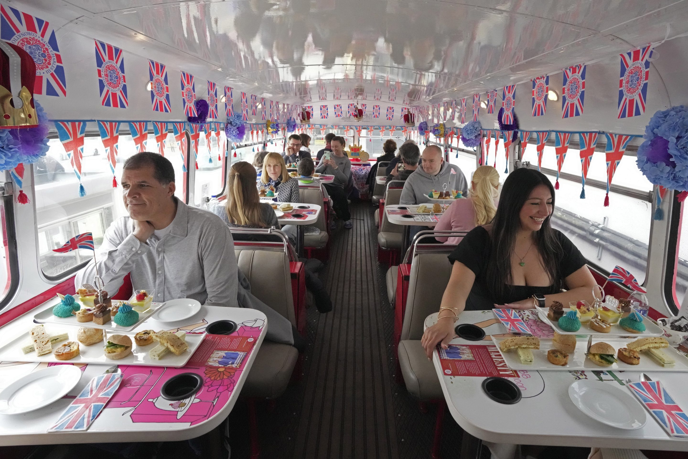 Tourists sit on a Coronation Tour Bus, in London, Monday, April 24, 2023.