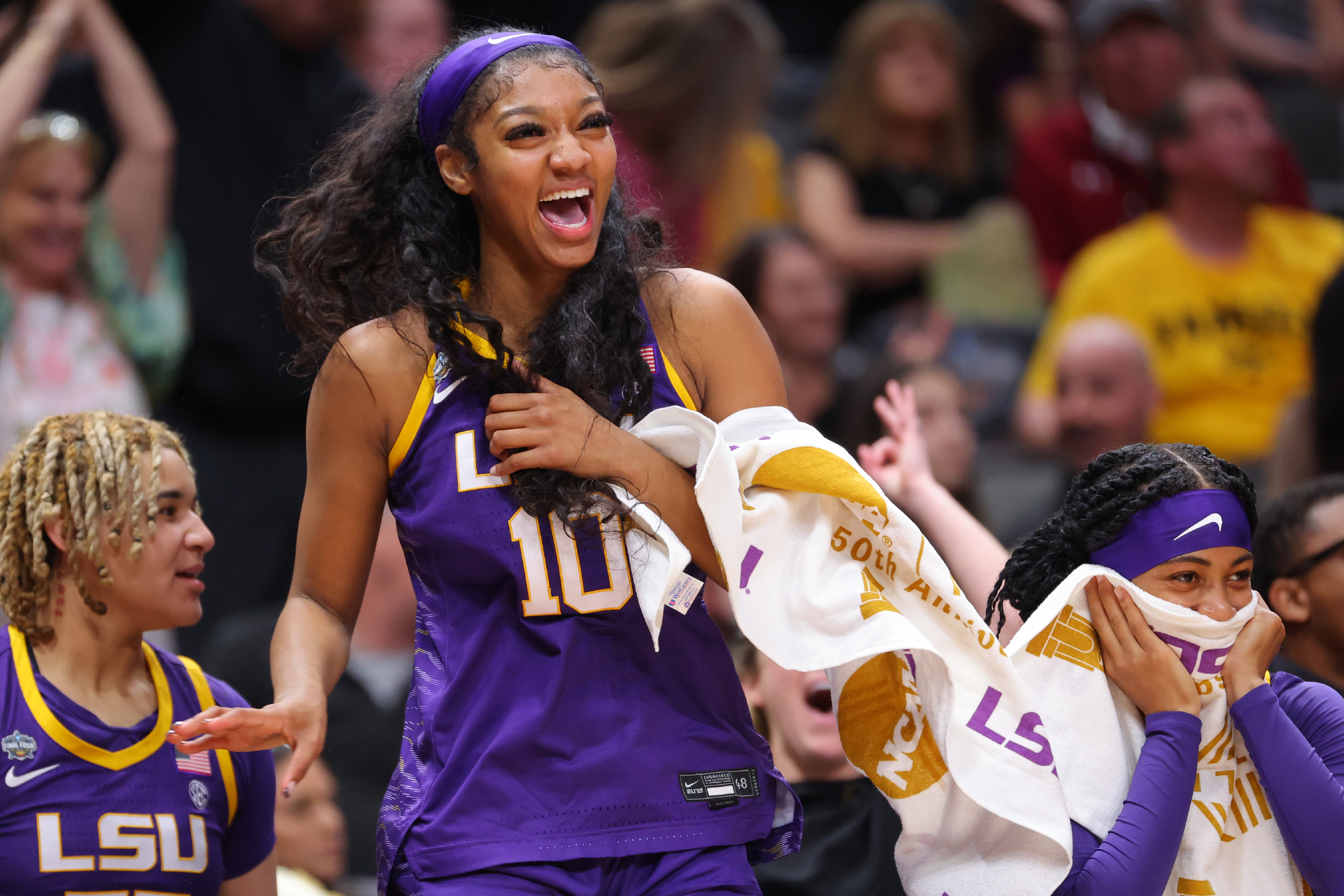 Angel Reese of the Louisiana State Tigers smiles from the bench as her team scores against the Iowa Hawkeyes during the 2023 NCAA Women's Basketball Tournament National Championship.