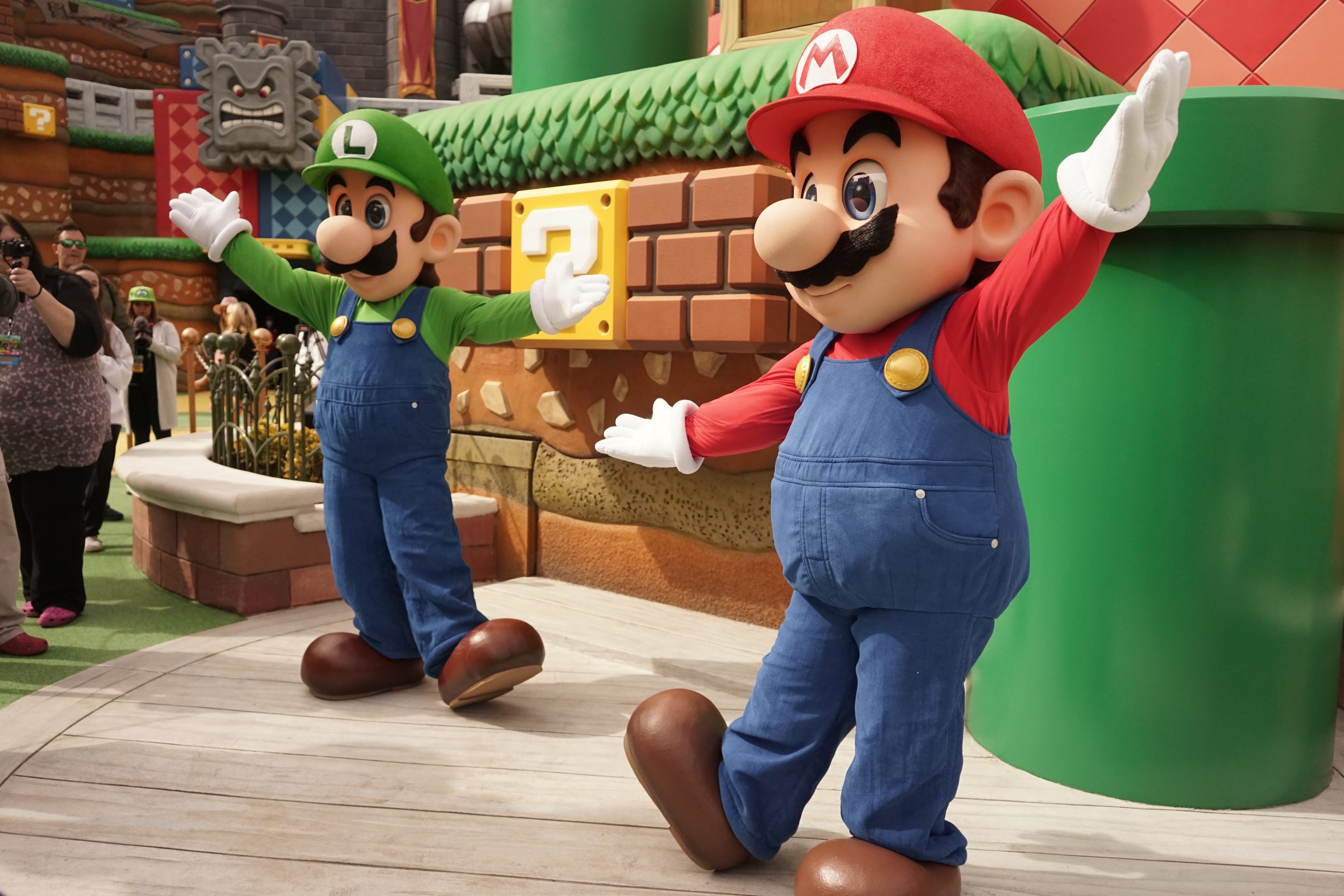 Staff members dressed up as Super Mario and Luigi interact with visitors on Preview Day at Super Nintendo World of Universal Studios Hollywood in Los Angeles, the United States, on Feb. 16, 2023.