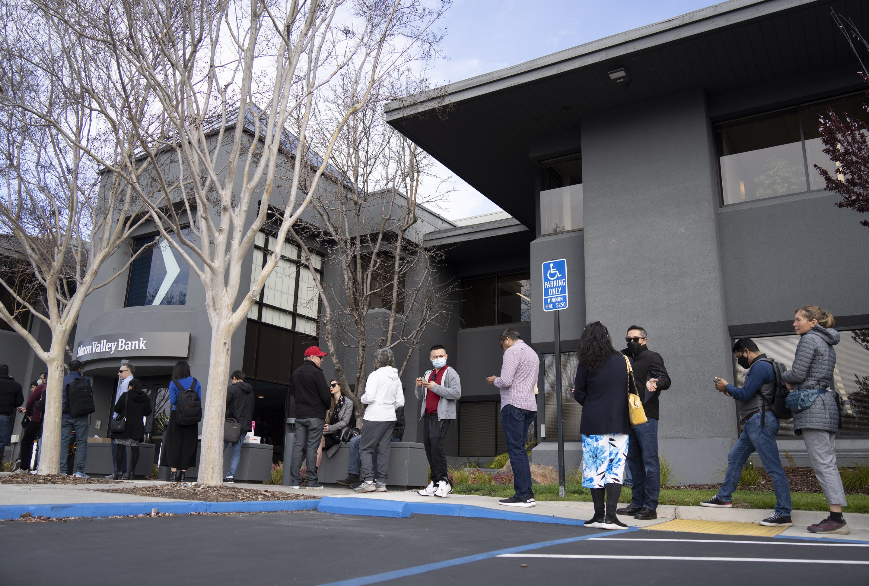 SANTA CLARA, CA - MARCH 13: People queue up outside the headquarters of Silicon Valley Bank to withdraw their funds on March 13, 2023 in Santa Clara, California. 