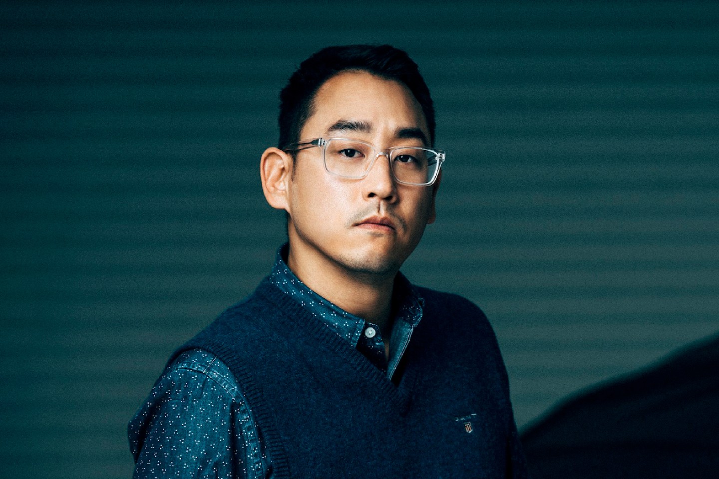 Portrait of Richard Kim on blue striped background.