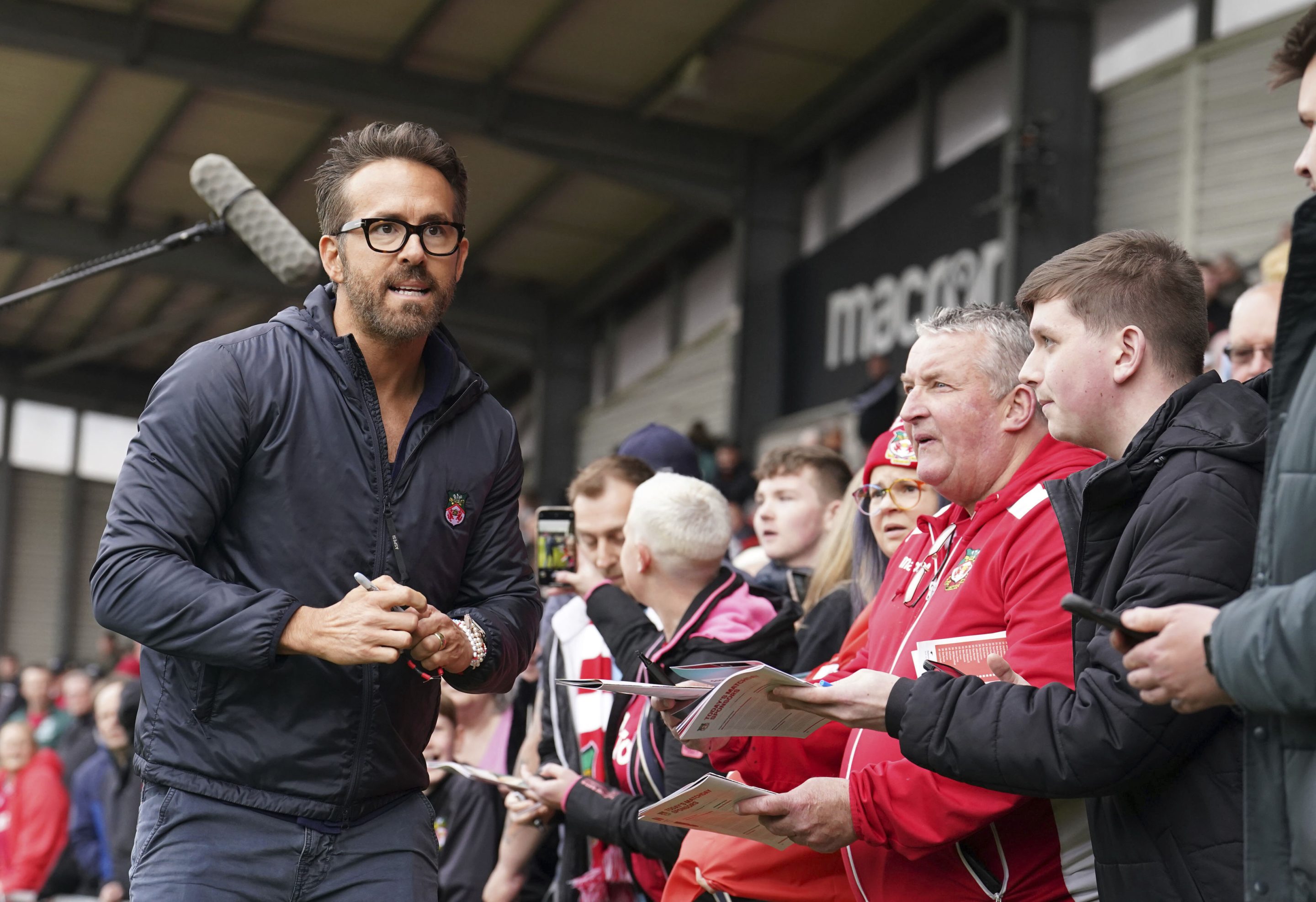 Wrexham co-owner Ryan Reynolds signs autographs ahead of the National League soccer match between Wrexham and Boreham Wood at The Racecourse Ground, in Wrexham, Wales, on April 22, 2023.