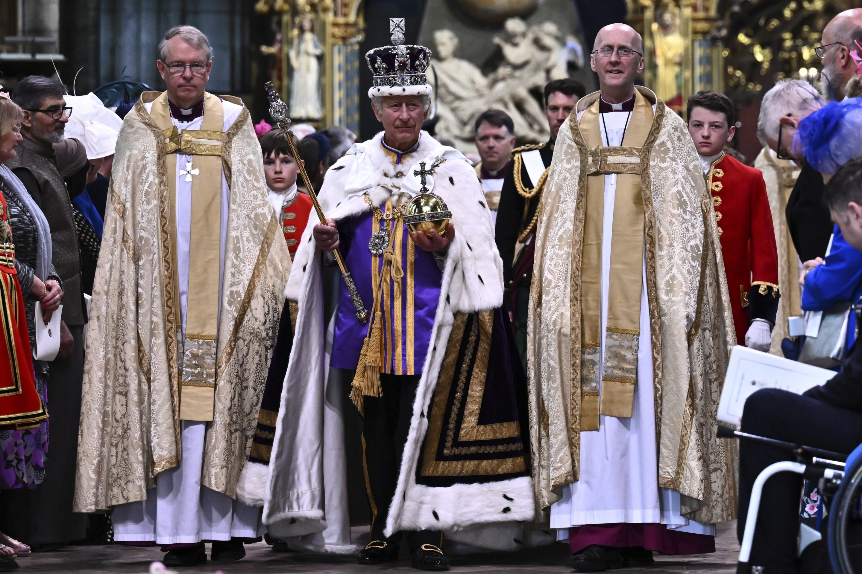 Britain's King Charles III wearing the Imperial state Crown and carrying the Sovereign's Orb and Sceptre leaves Westminster Abbey after coronation in central London Saturday, May 6, 2023. 