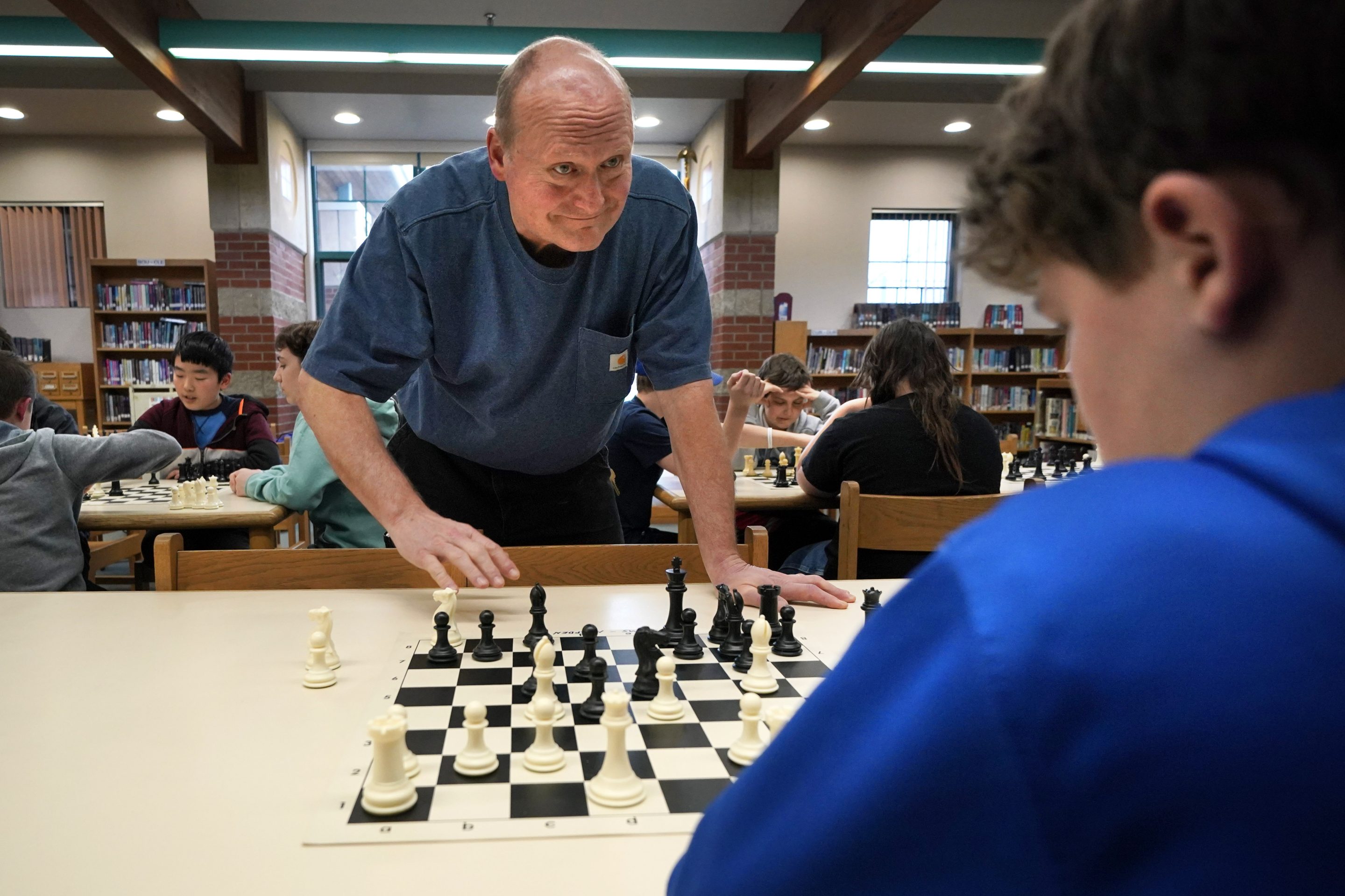 Custodian and chess coach David Bishop challenges 6th-grader Owen Isenhour during after-school practice, Tuesday, April 25, 2023, in Hampden, Maine.