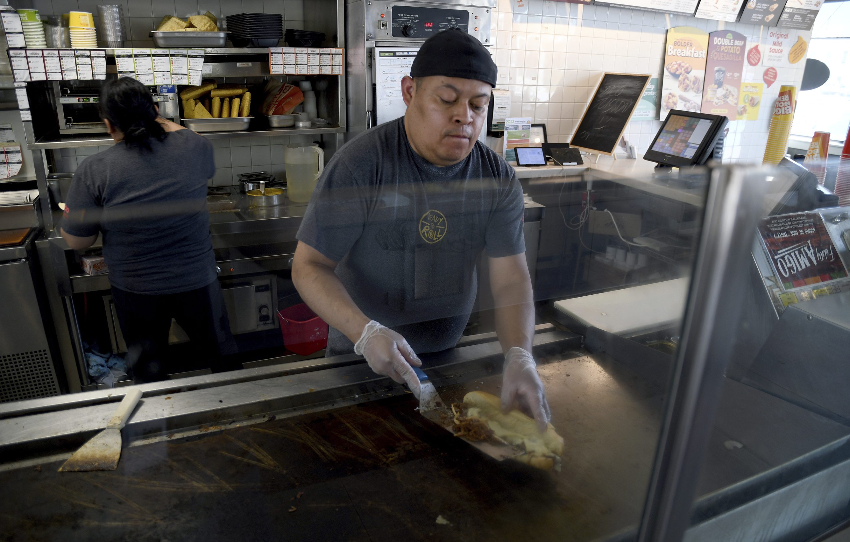 Ricardo Acosta prepares food at a Taco John's restaurant in Denver on Tuesday, May 16, 2023. Taco Bell is asking U.S. regulators to force Wyoming-based Taco John's to abandon its longstanding claim to the "Taco Tuesday" trademark.