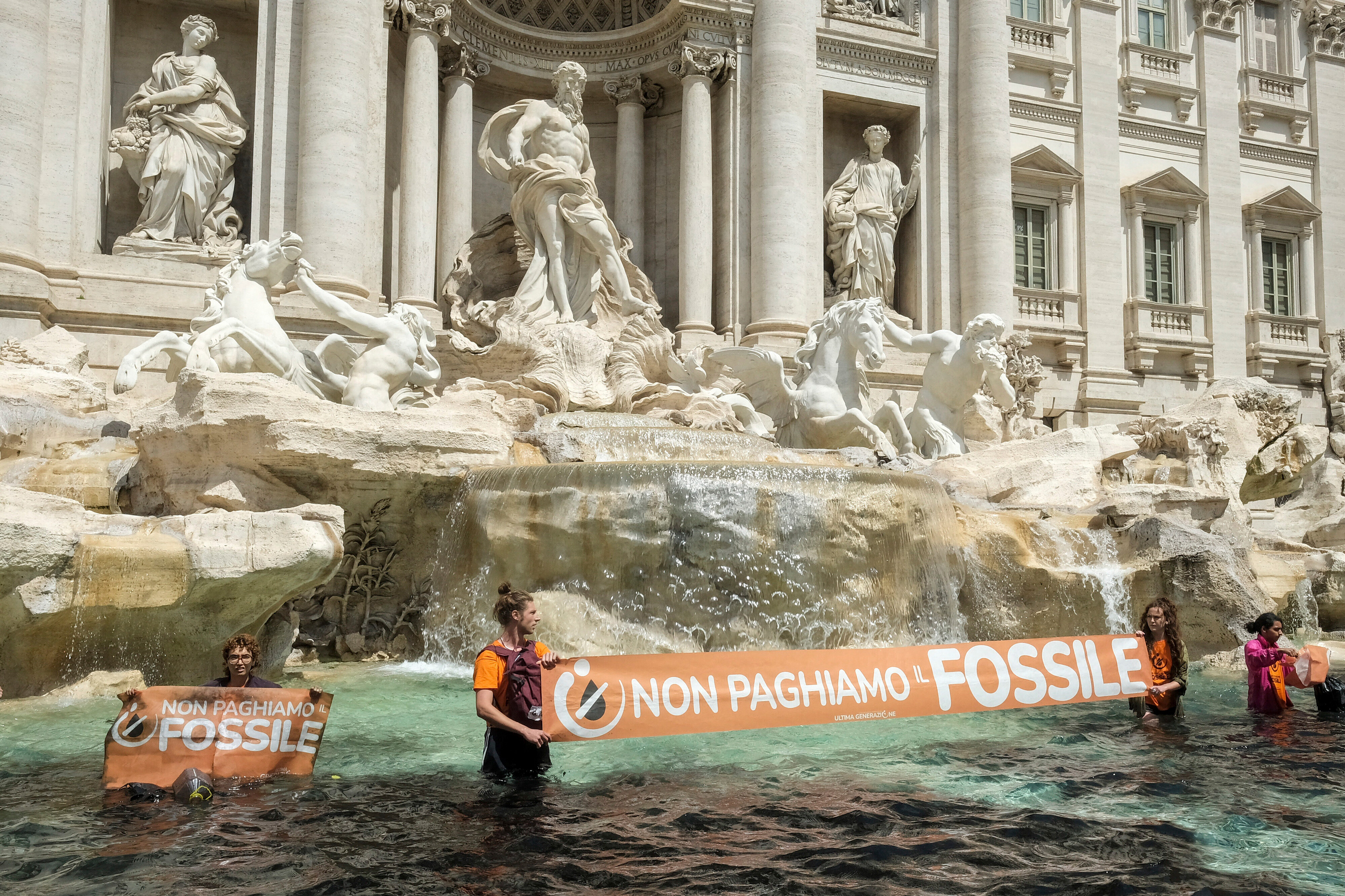 Last Generation environmentalists in the Trevi Fountain in Rome show a banner against the use of fossil fuels  on Sunday, May 21, 2023.