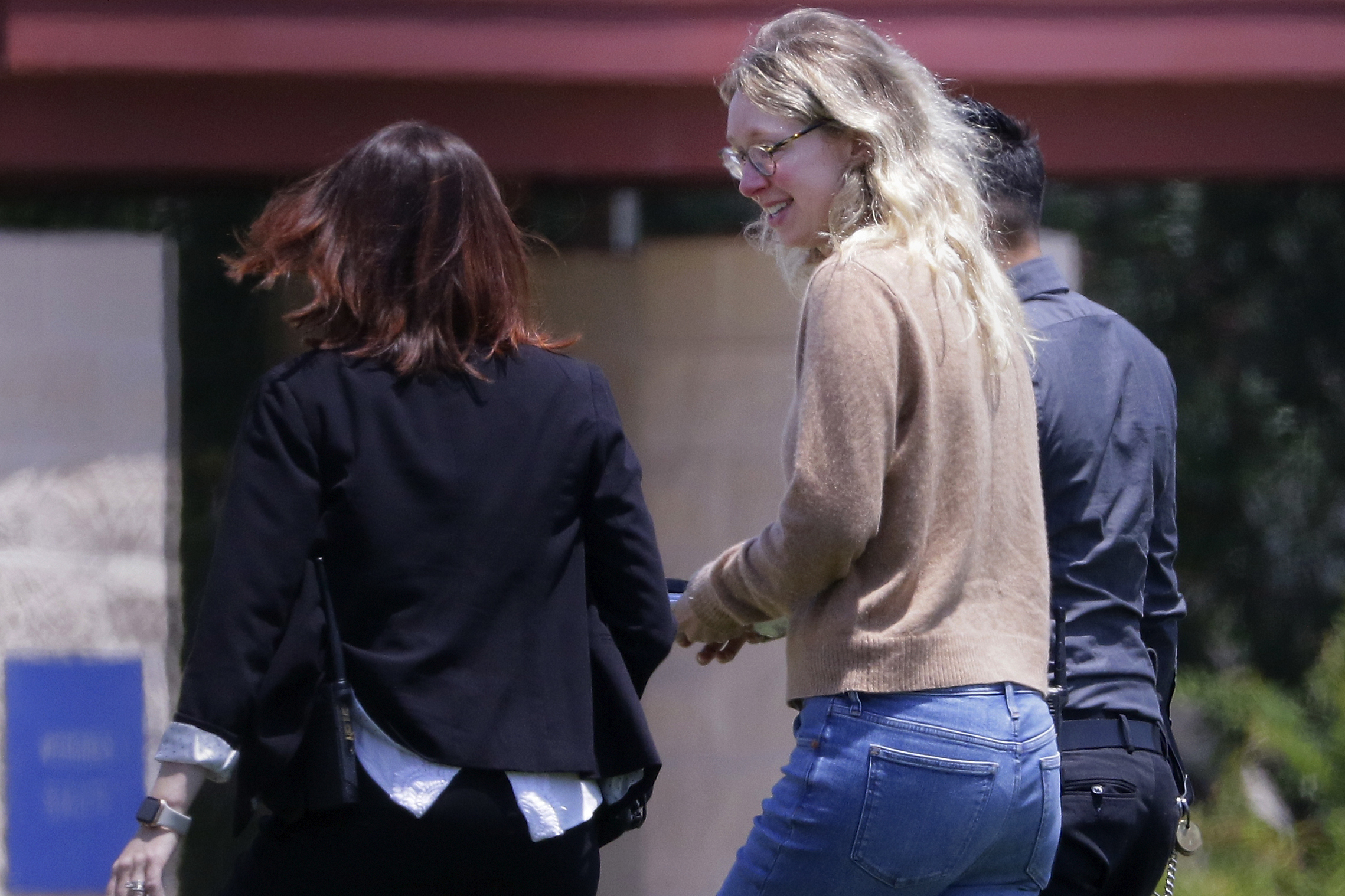 Disgraced Theranos CEO Elizabeth Holmes, center, is escorted by prison officials into a federal women’s prison camp on May 30, 2023, in Bryan, Texas.