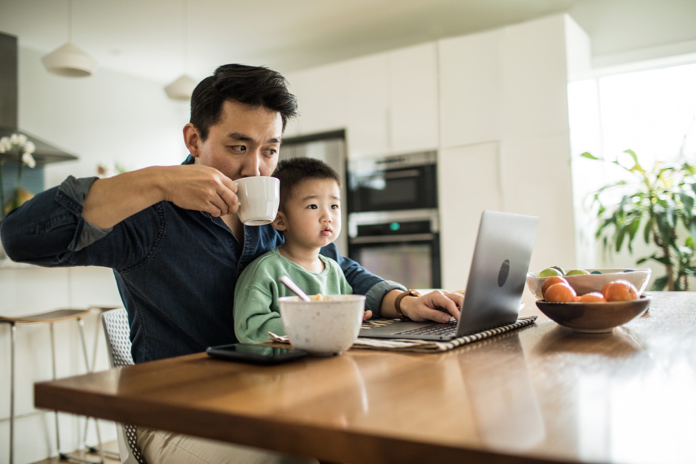 Father working with son on his lap