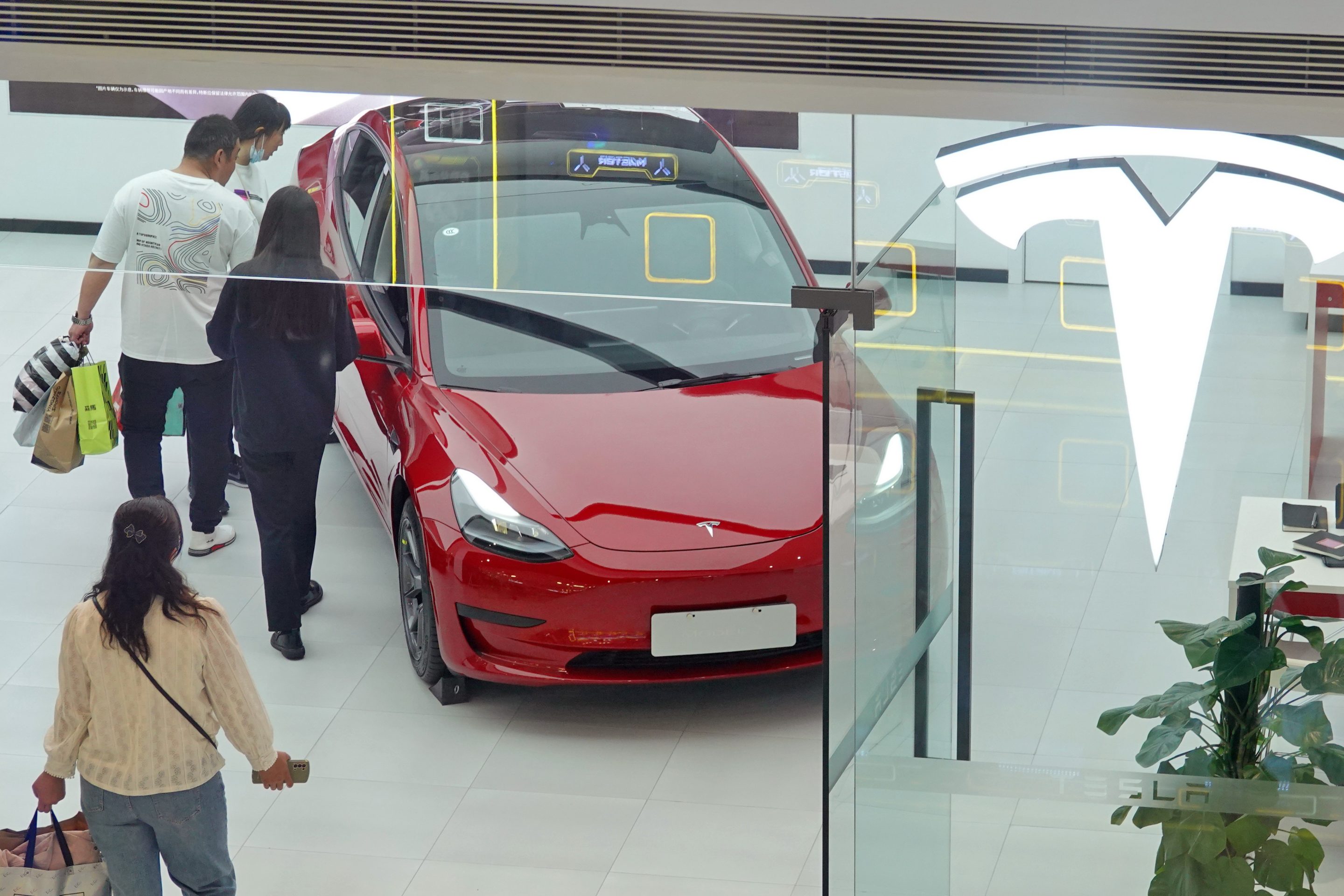 Customers learn about the Tesla Model Y at a Tesla store in Yantai, East China's Shandong province, May 5, 2023.