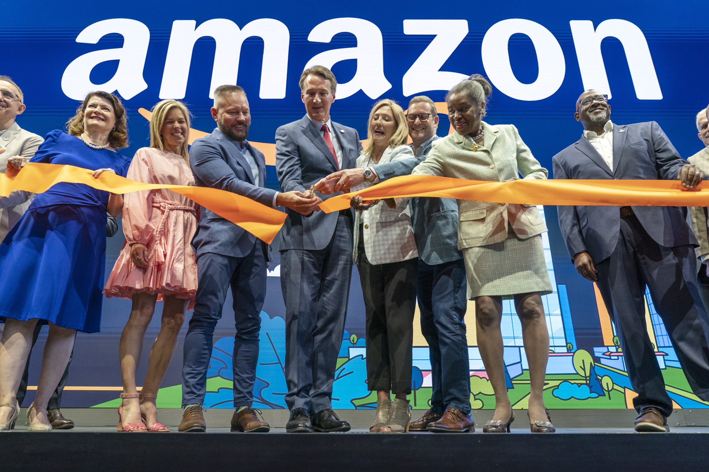 Virginia Gov. Glenn Youngkin, center, with Holly Sullivan, Vice President of Economic Development at Amazon, center right, cut the ribbon during a grand opening ceremony at Amazon's second headquarters, HQ2, in Arlington, Va., on June 15, 2023. 