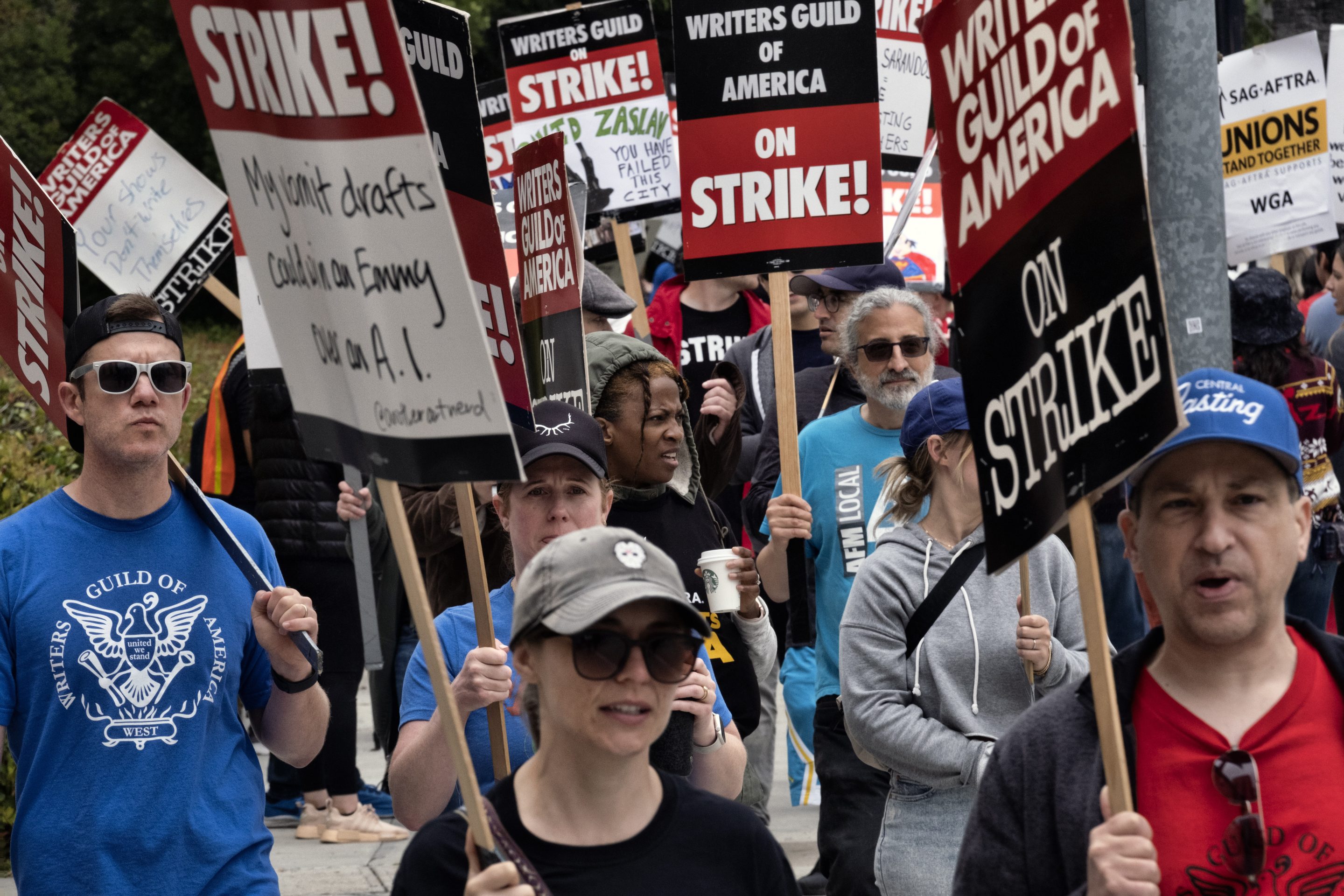 Picketers pass near a studio entrance during a Writers Guild rally outside Warner Bros. Studios, on May 24, 2023, in Burbank, Calif. 