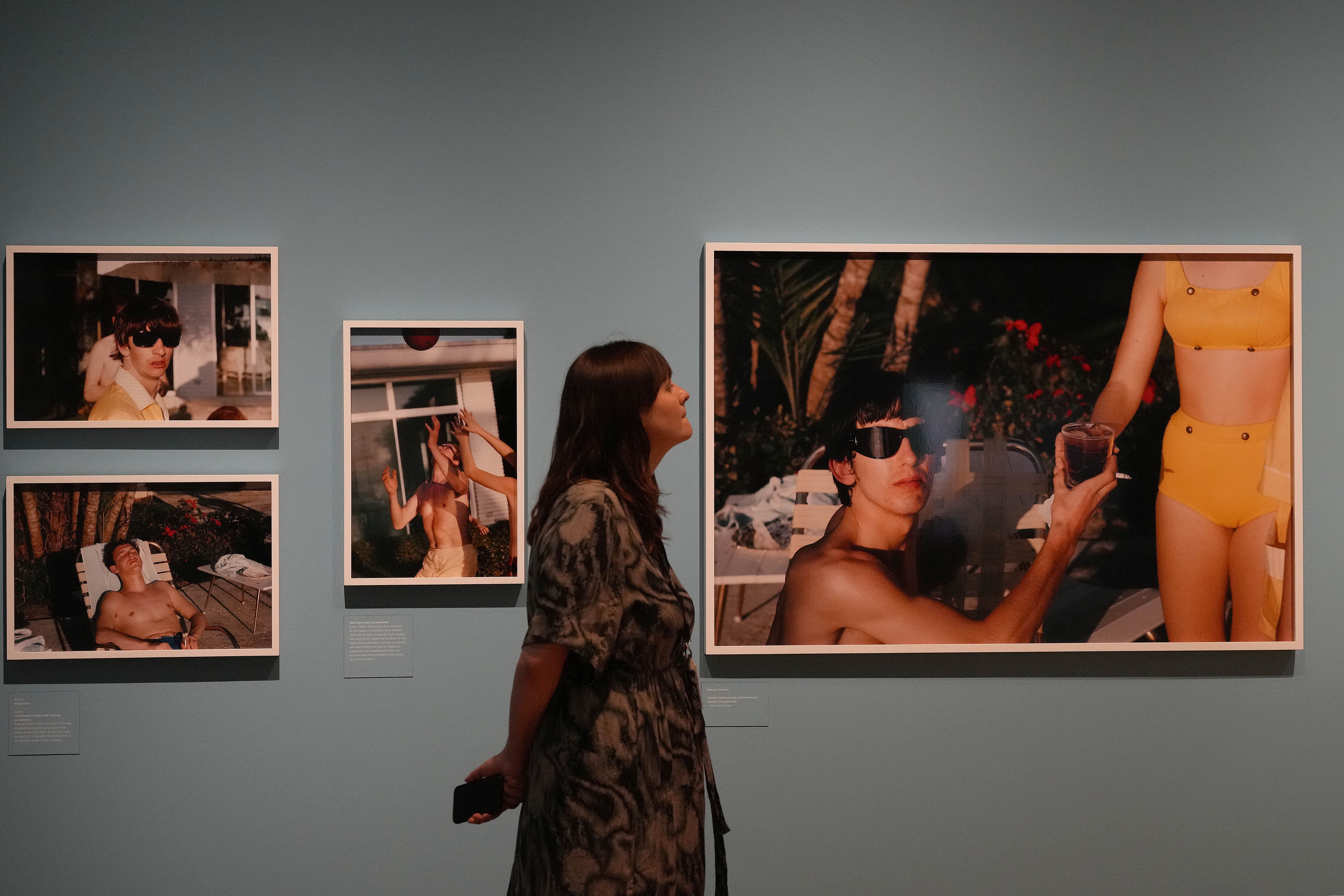 A woman strolls in an art gallery.