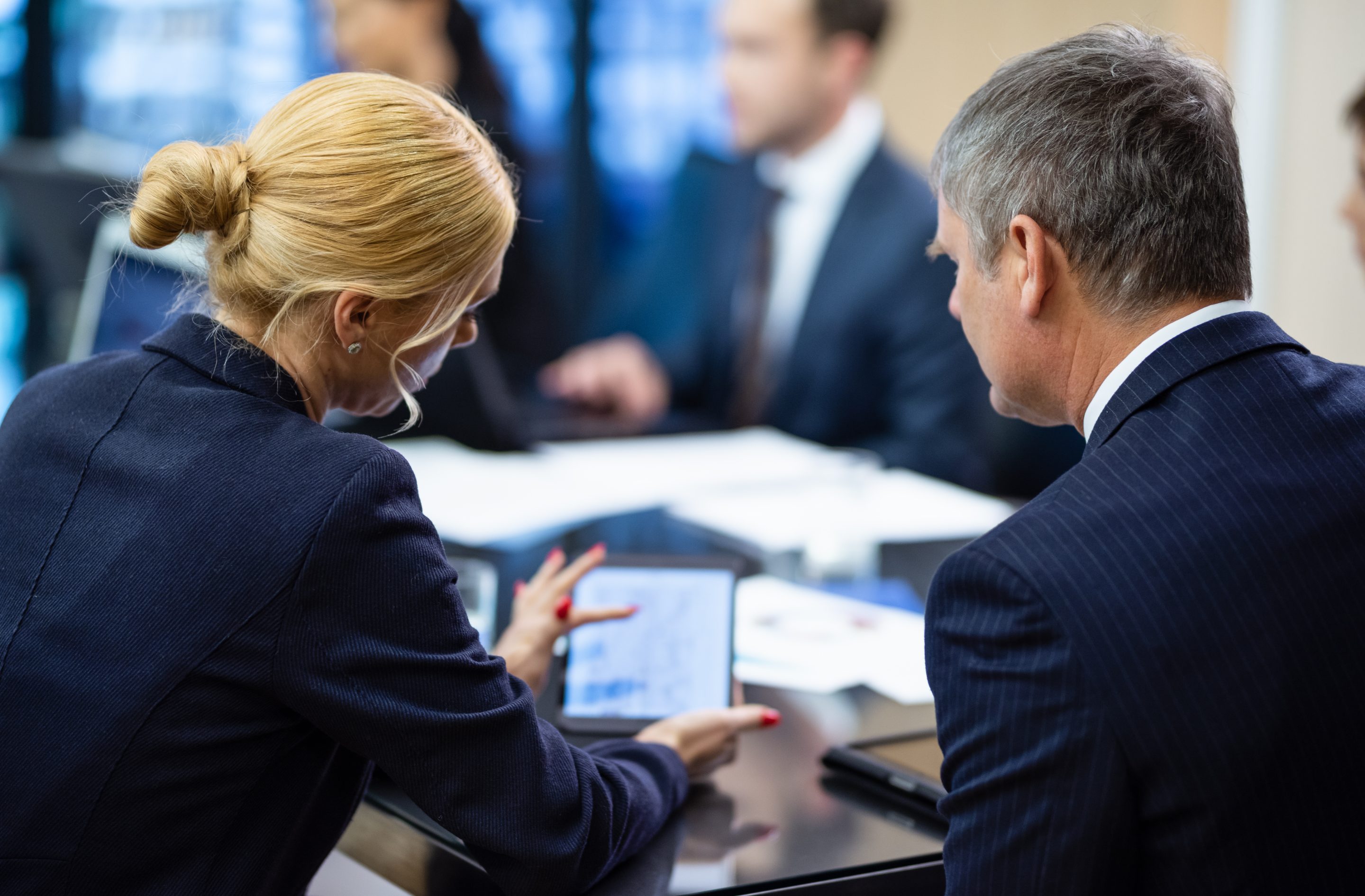 Group of people sitting at a conference table having meeting and talking.