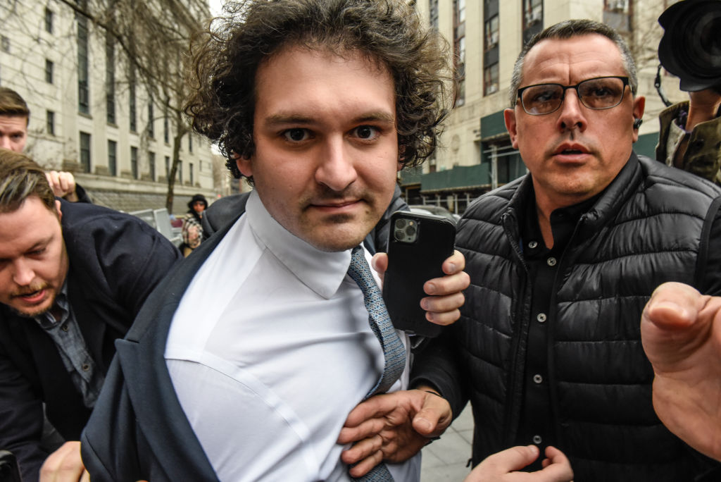 Man with brown, curly hair departing from a court building