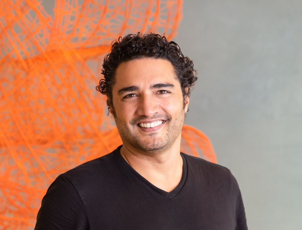 Man with dark curly hair wearing a black t-shirt