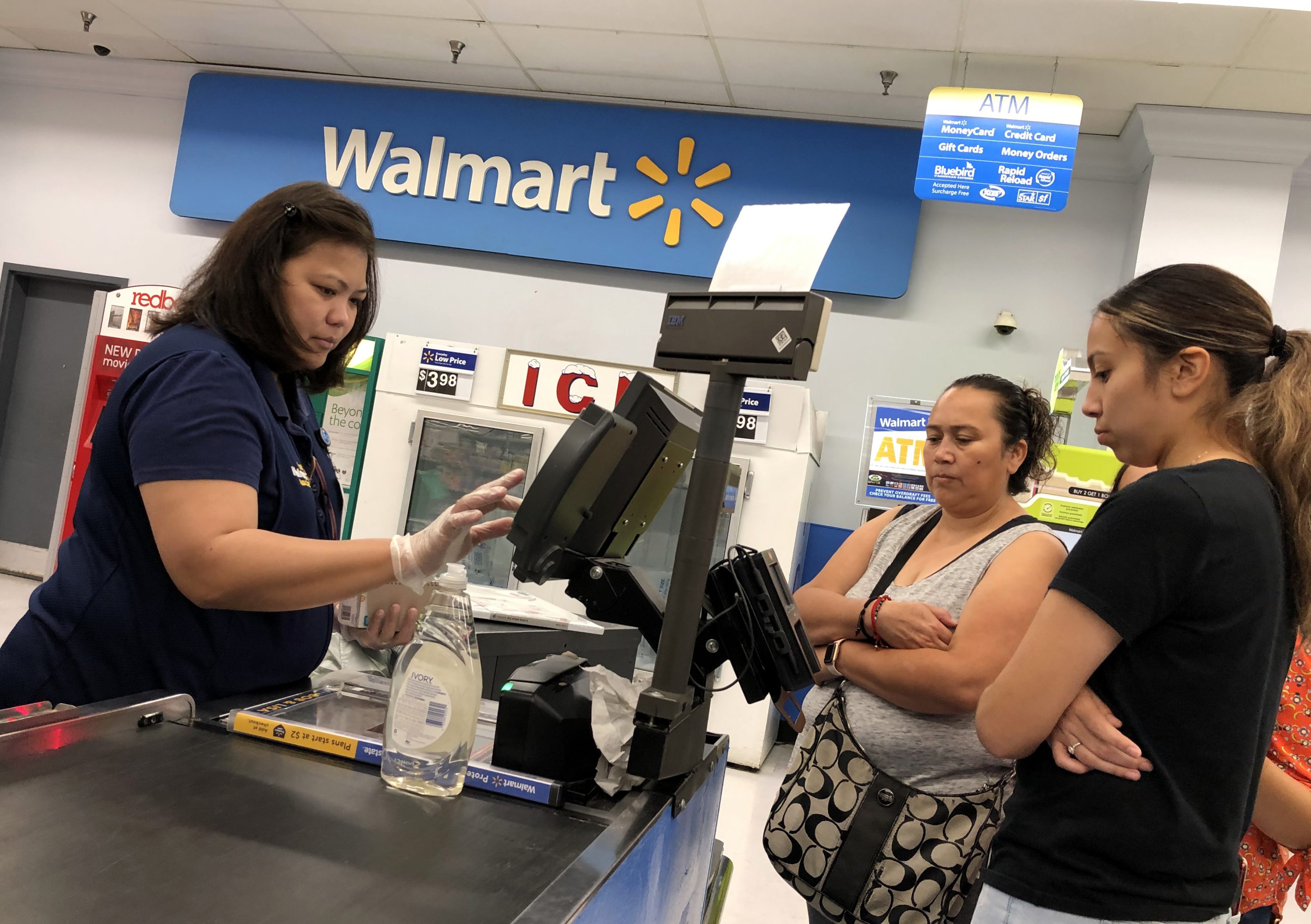 A Walmart cashier with customers. 
