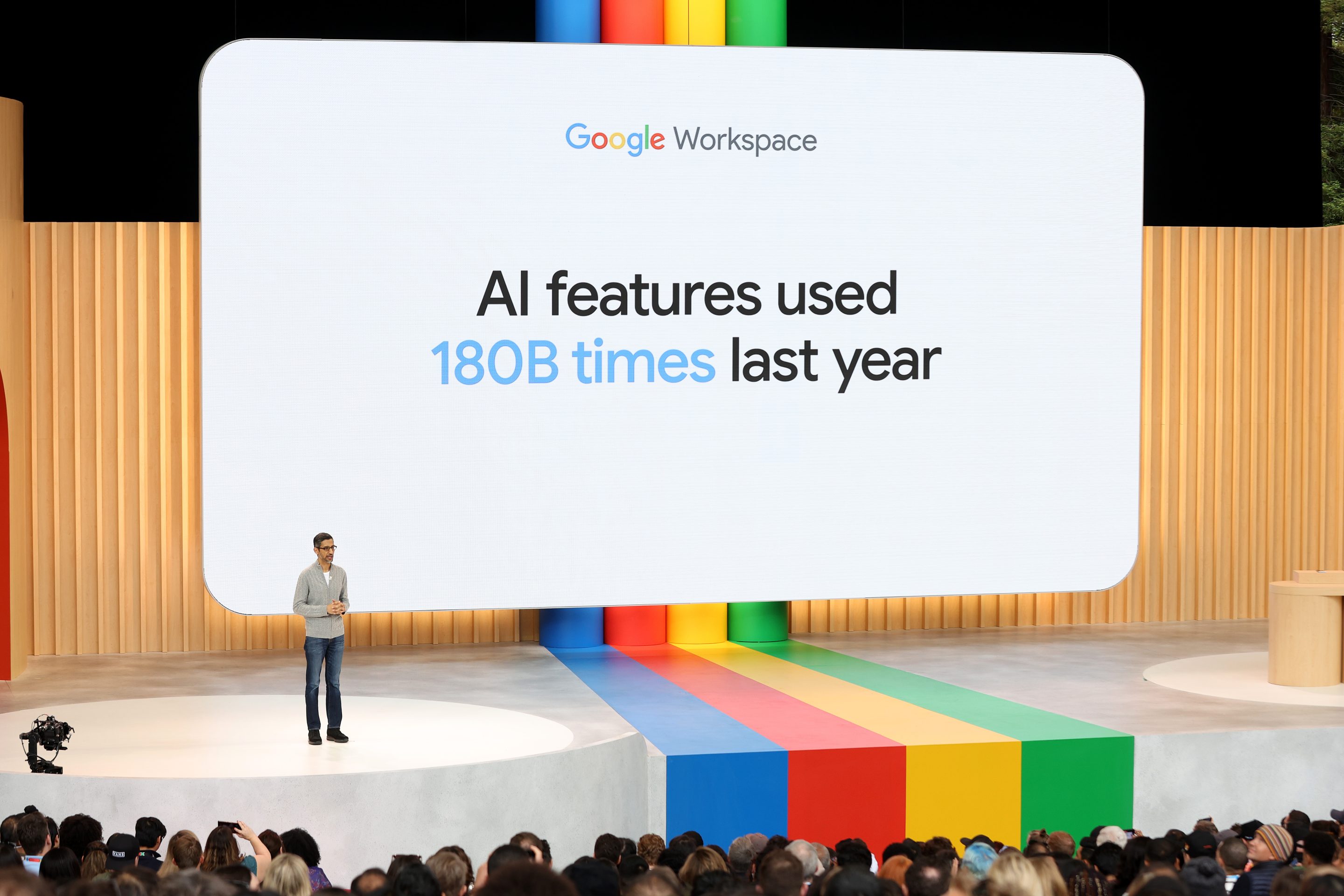 Alphabet CEO Sundar Pichai stands in front of a presentation.