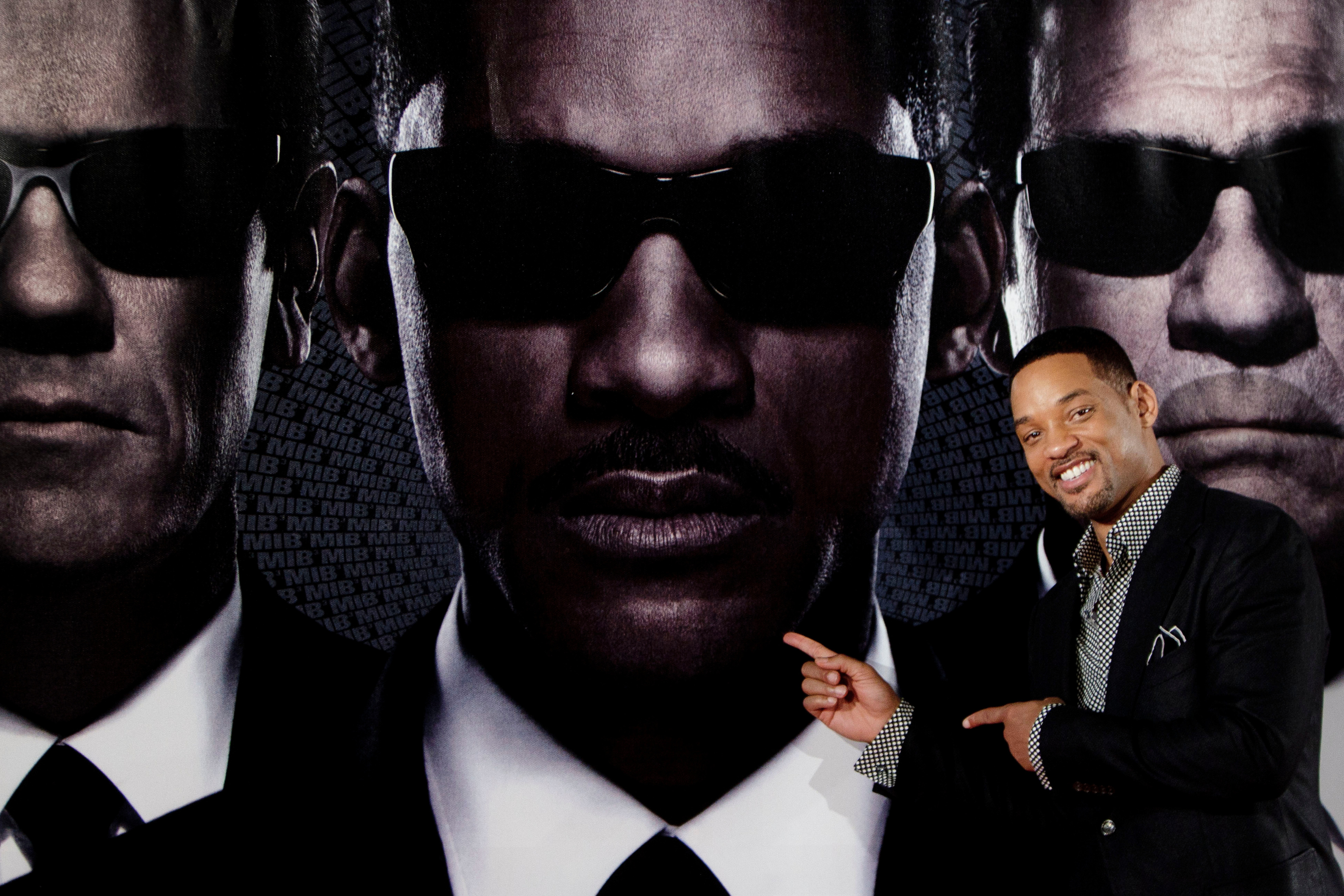 Will Smith in front of a Men in Black poster