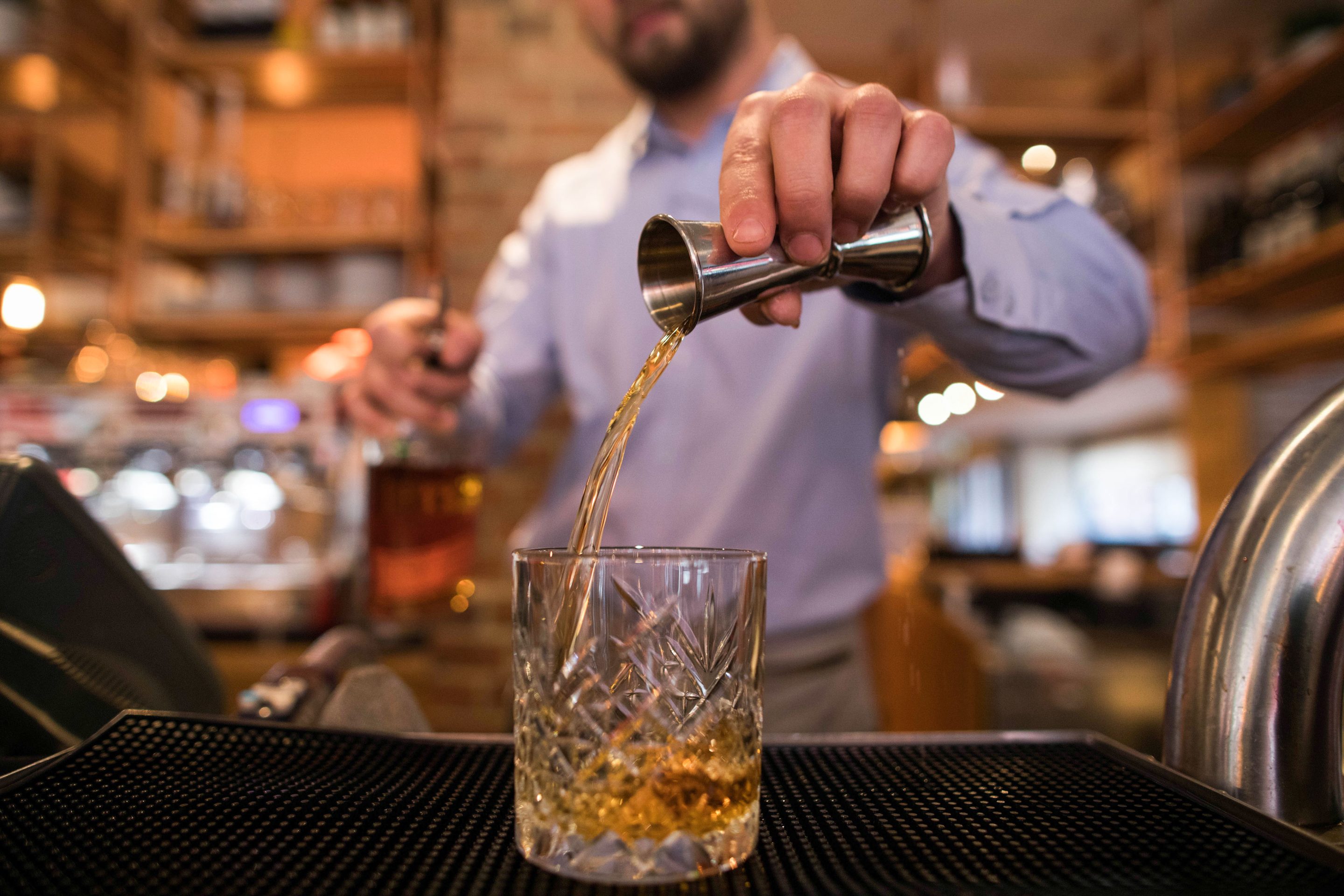 A waiter pours a bourbon whisky.