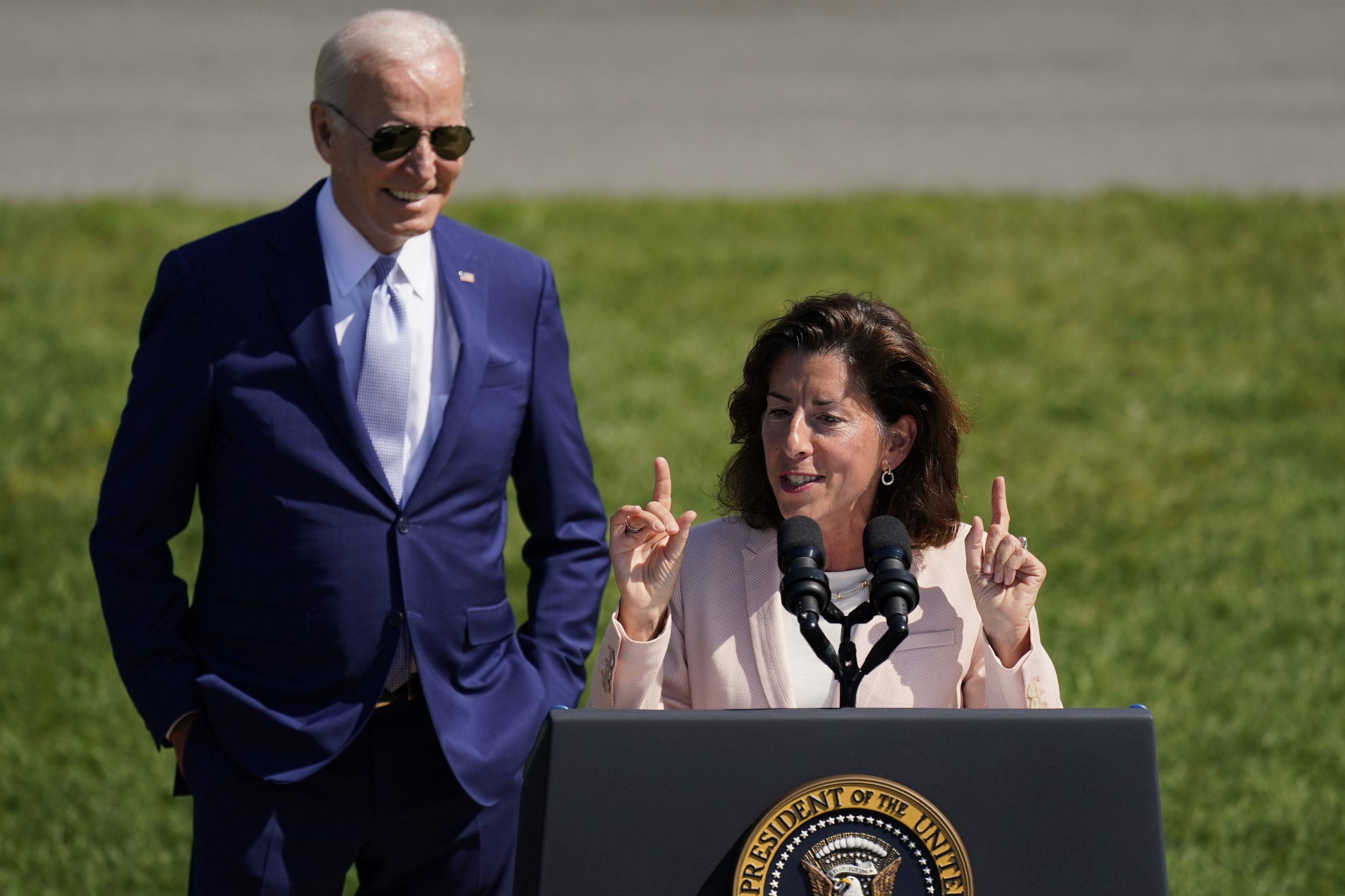 President Joe Biden looks on as Commerce Secretary Gina Raimondo speaks on the South Lawn of the White House, Aug. 9, 2022, in Washington. 