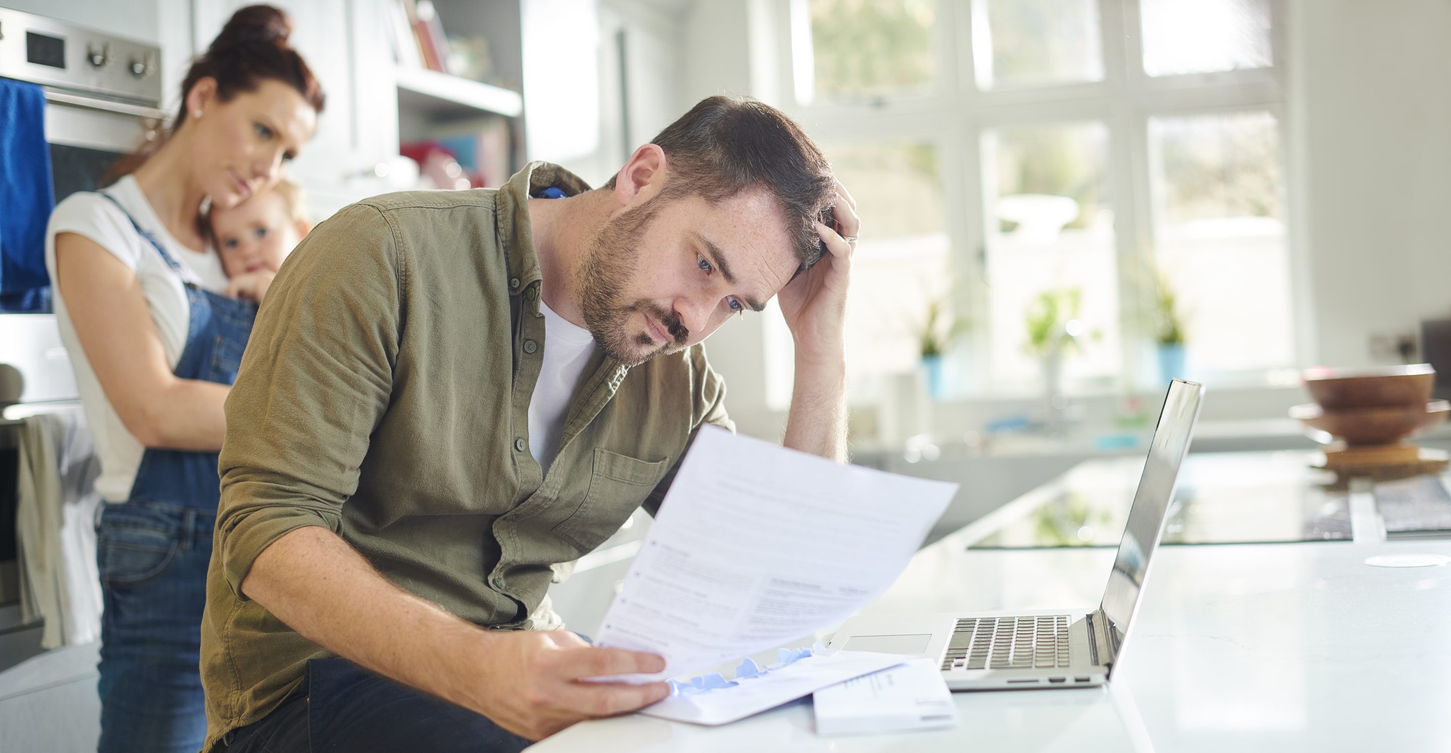 Photo of a young man looking seriously at a financial statement