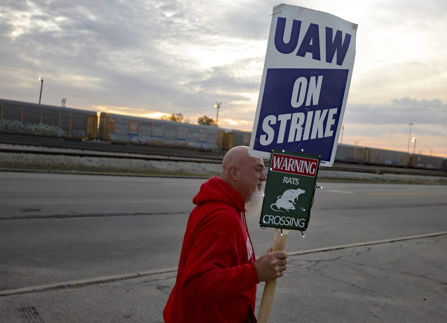 A UAW autoworker picketing in front of a Stellantis assembly plant