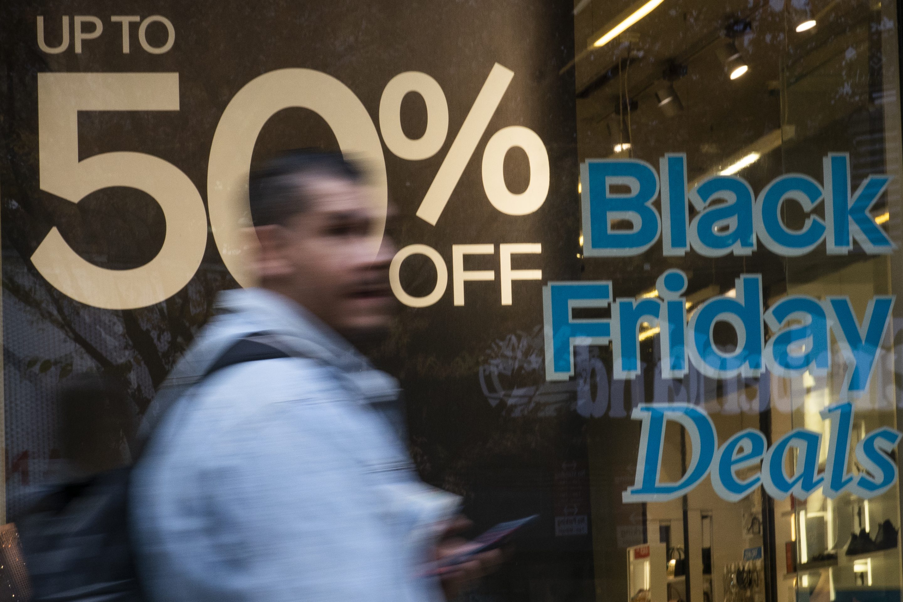 A man walks near a local store in preparation for Black Friday