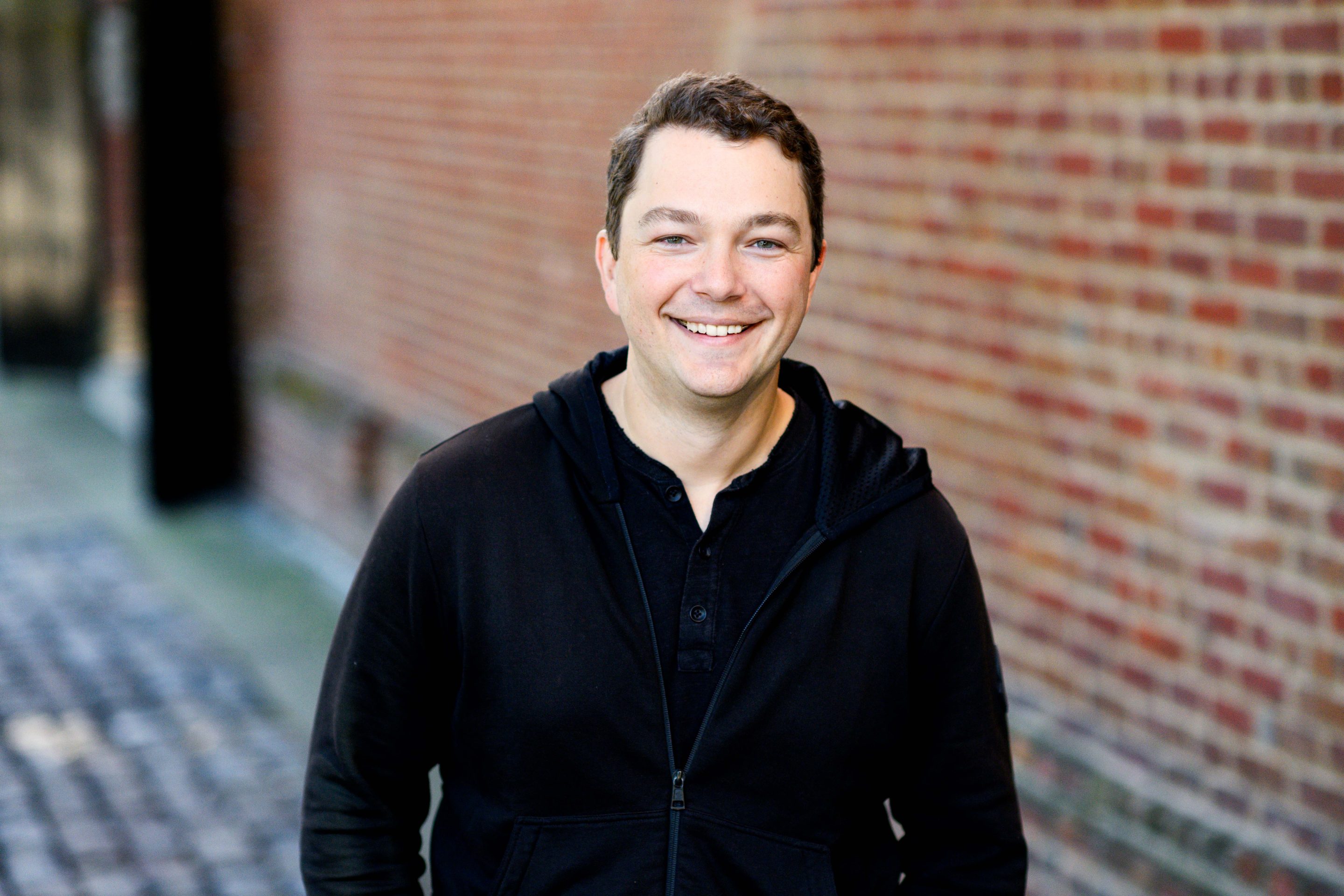 man wearing black jacket and smiling