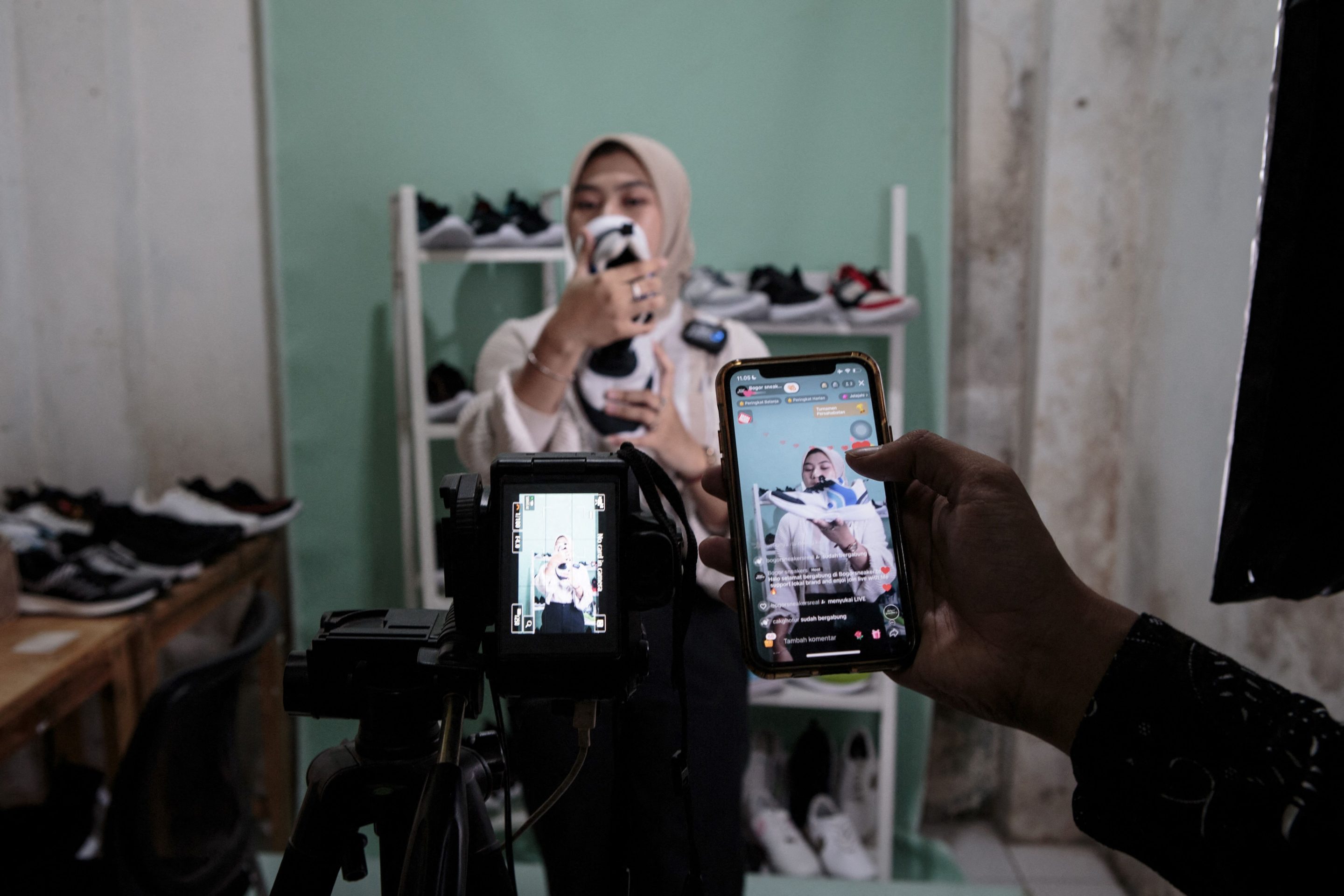 A staff of a small shoe manufacturer shows their new products for a video to be posted on social media on Sept. 27, 2023. TikTok was forced to close its e-commerce service in Indonesia after Jakarta implemented new rules in late September.