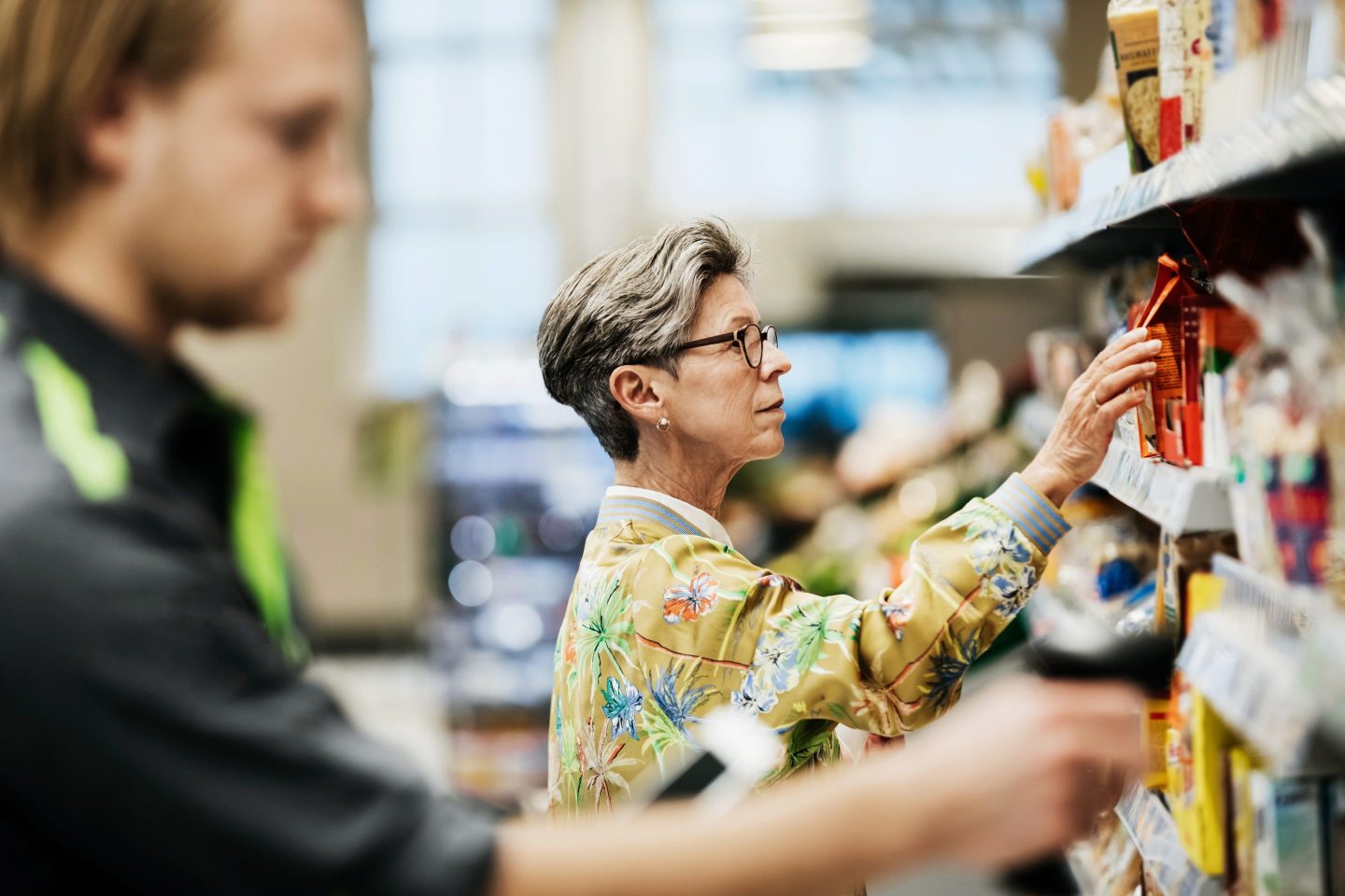 woman picking some goods from the shelf while out shopping for groceries at her local supermarket.