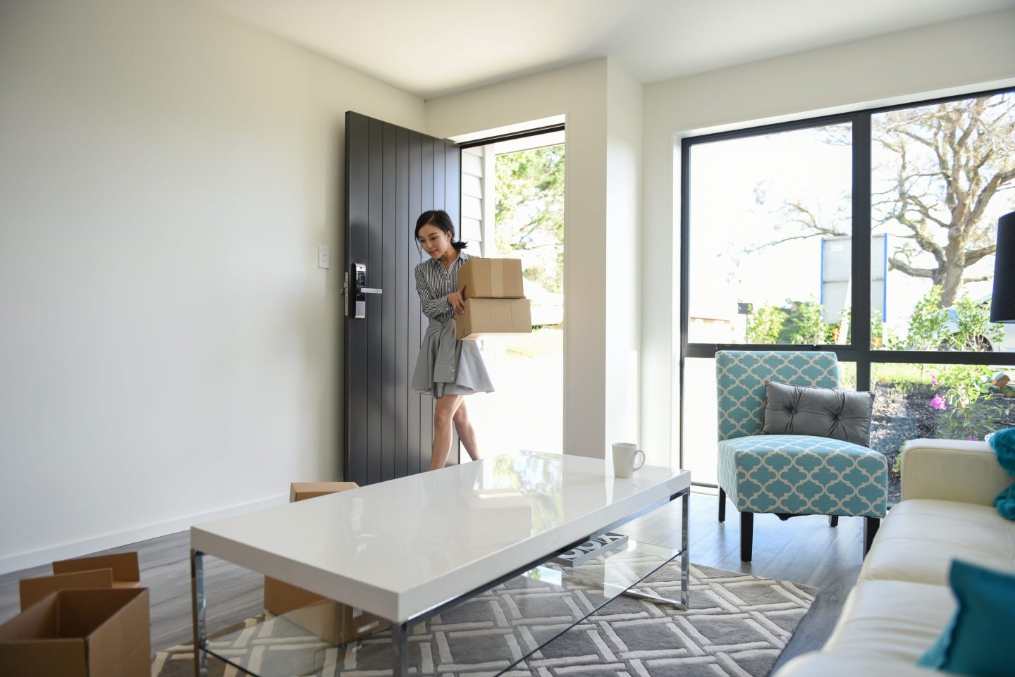 A young woman enters the door of a modern home