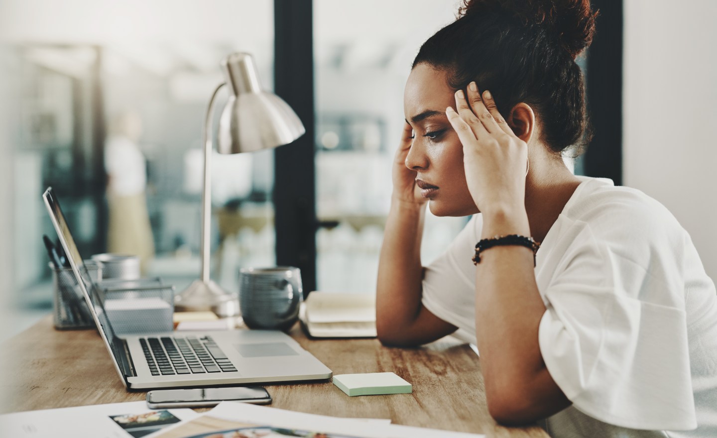 A young businesswoman appears stressed while using a laptop at home.