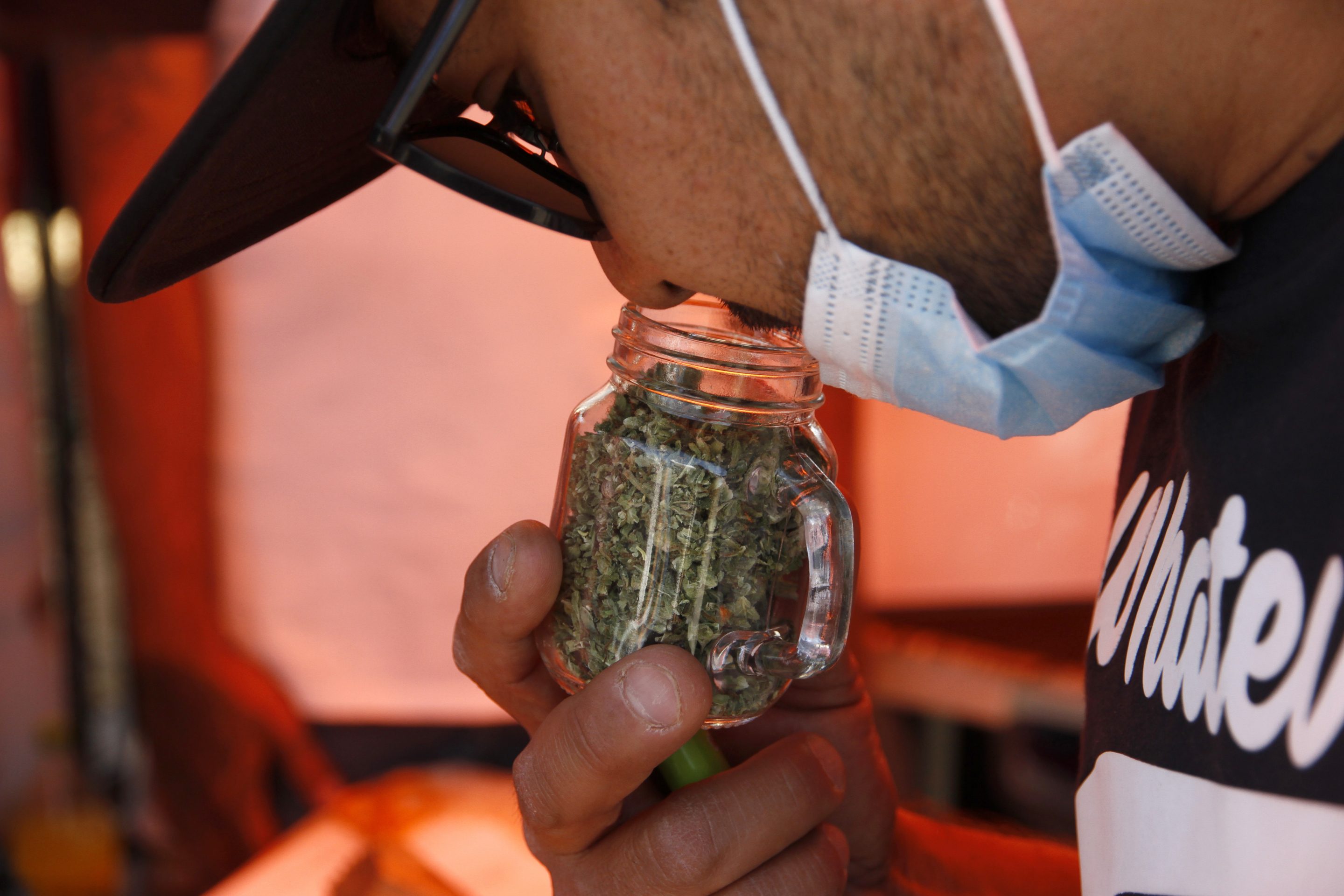 A person smell a jar with marijuan