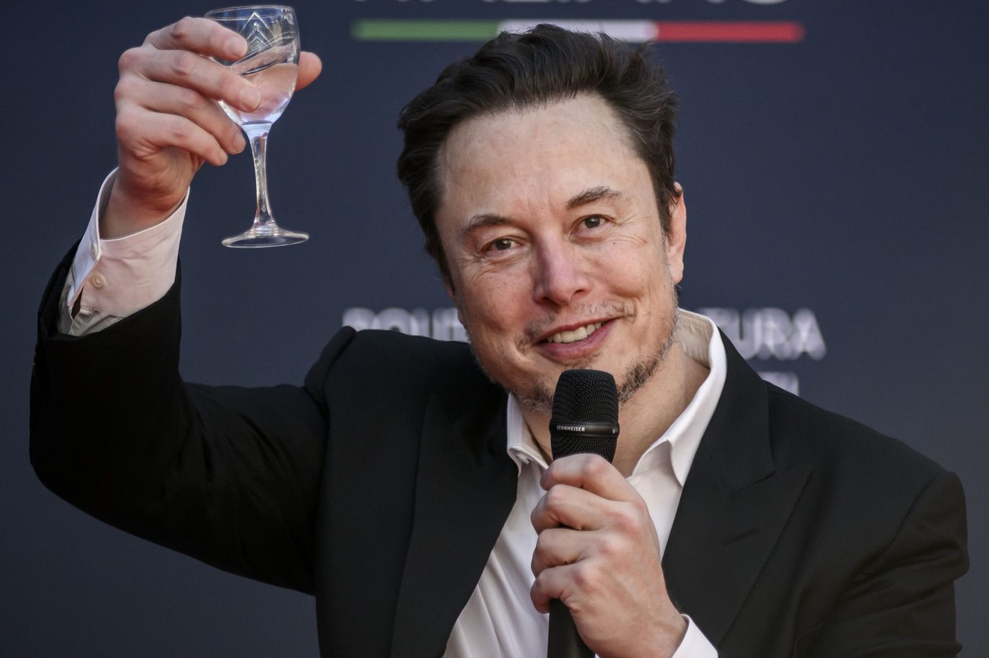X owner Elon Musk lifting a glass