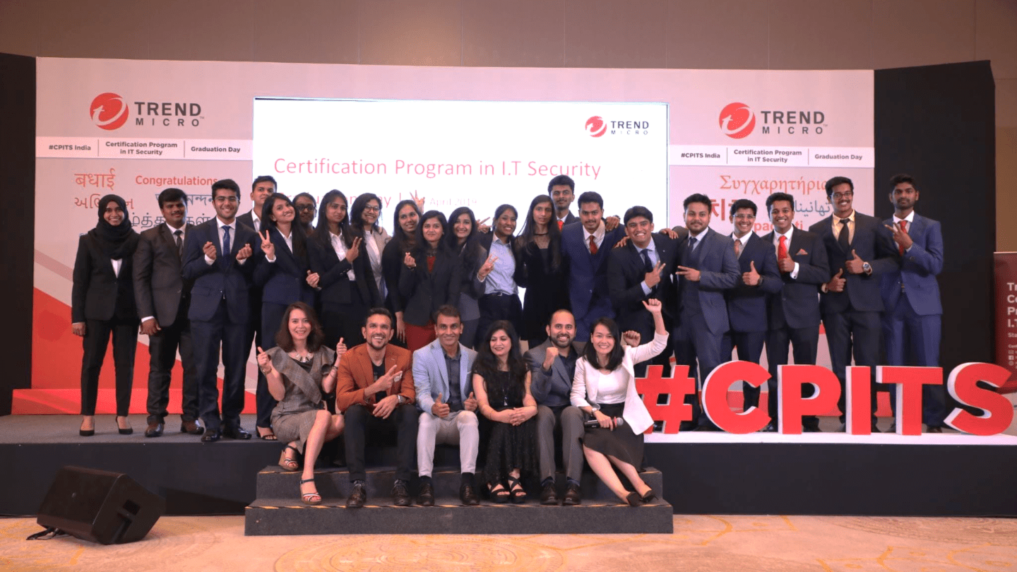 Graduates of Trend Micro's certification program sit and stand together.
