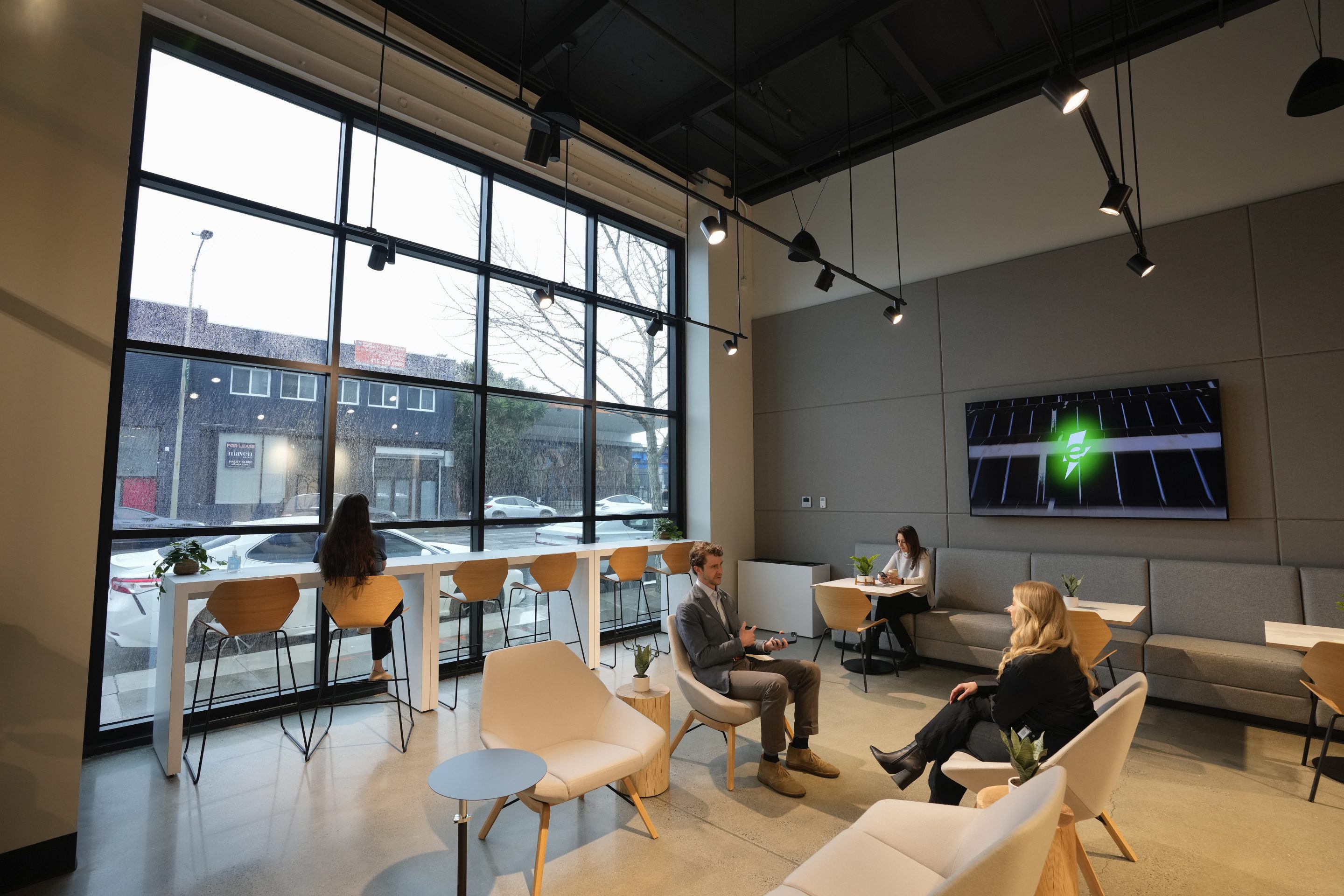 People sit in a waiting lounge at the new Electrify America indoor electric vehicle charging station in San Francisco, on Feb. 7, 2024. 