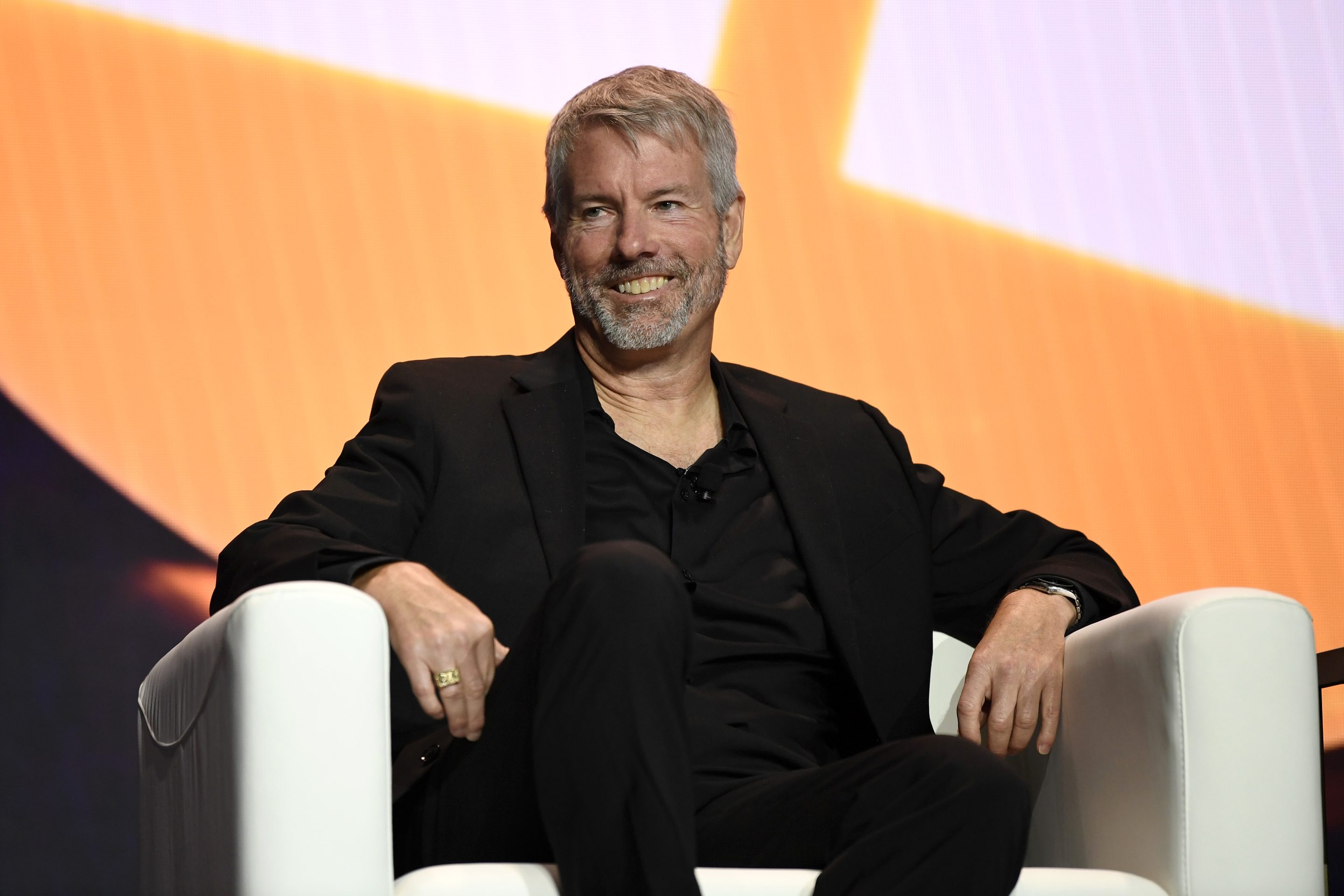 Billionaire Michael Saylor sitting on stage at a Bitcoin conference