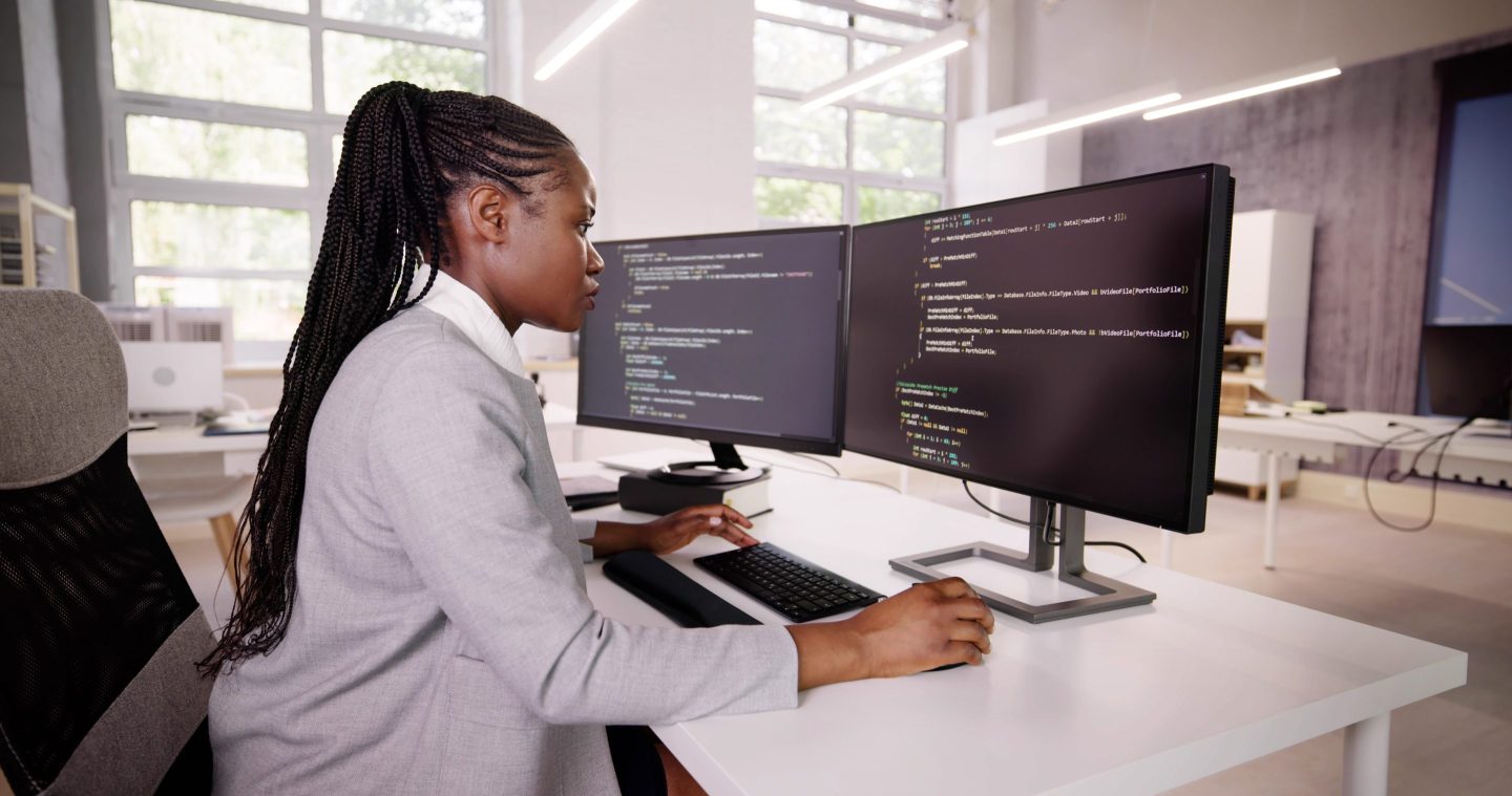 African American Coder Using Computer At Desk